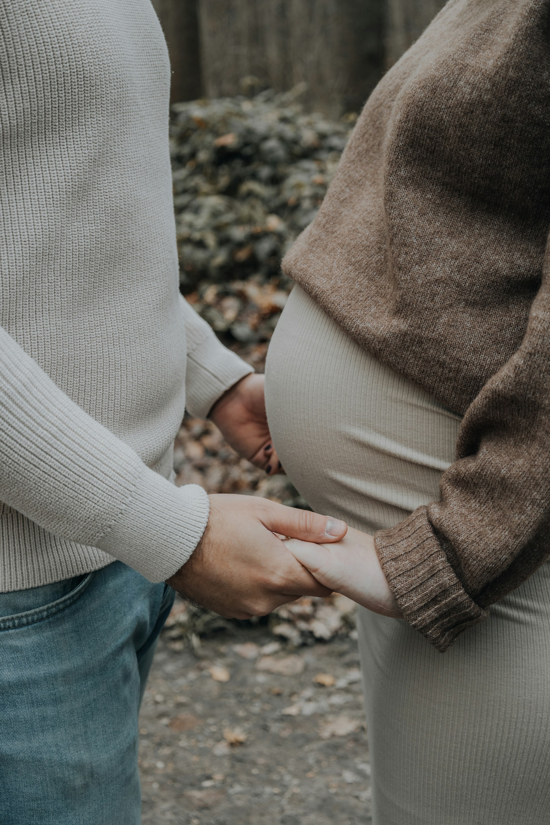 Un homme tenant les mains de sa partenaire enceinte | Source : Unsplash