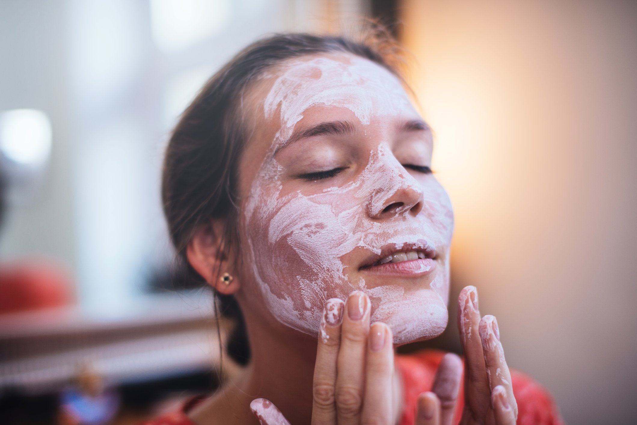 Une femme applique une crème sur son visage. | Photo : Getty Images