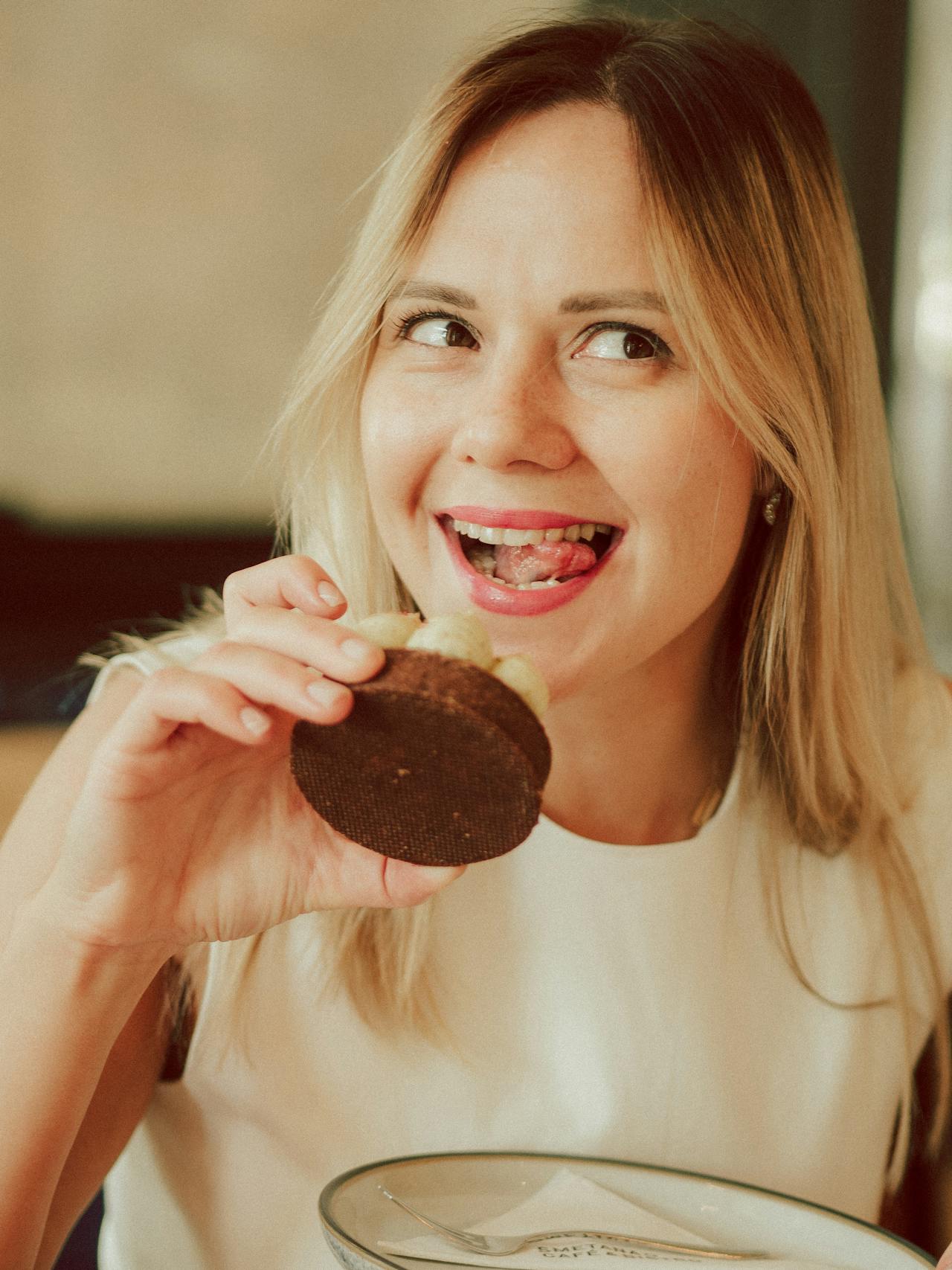 Une femme heureuse mangeant un petit gâteau | Source : Pexels