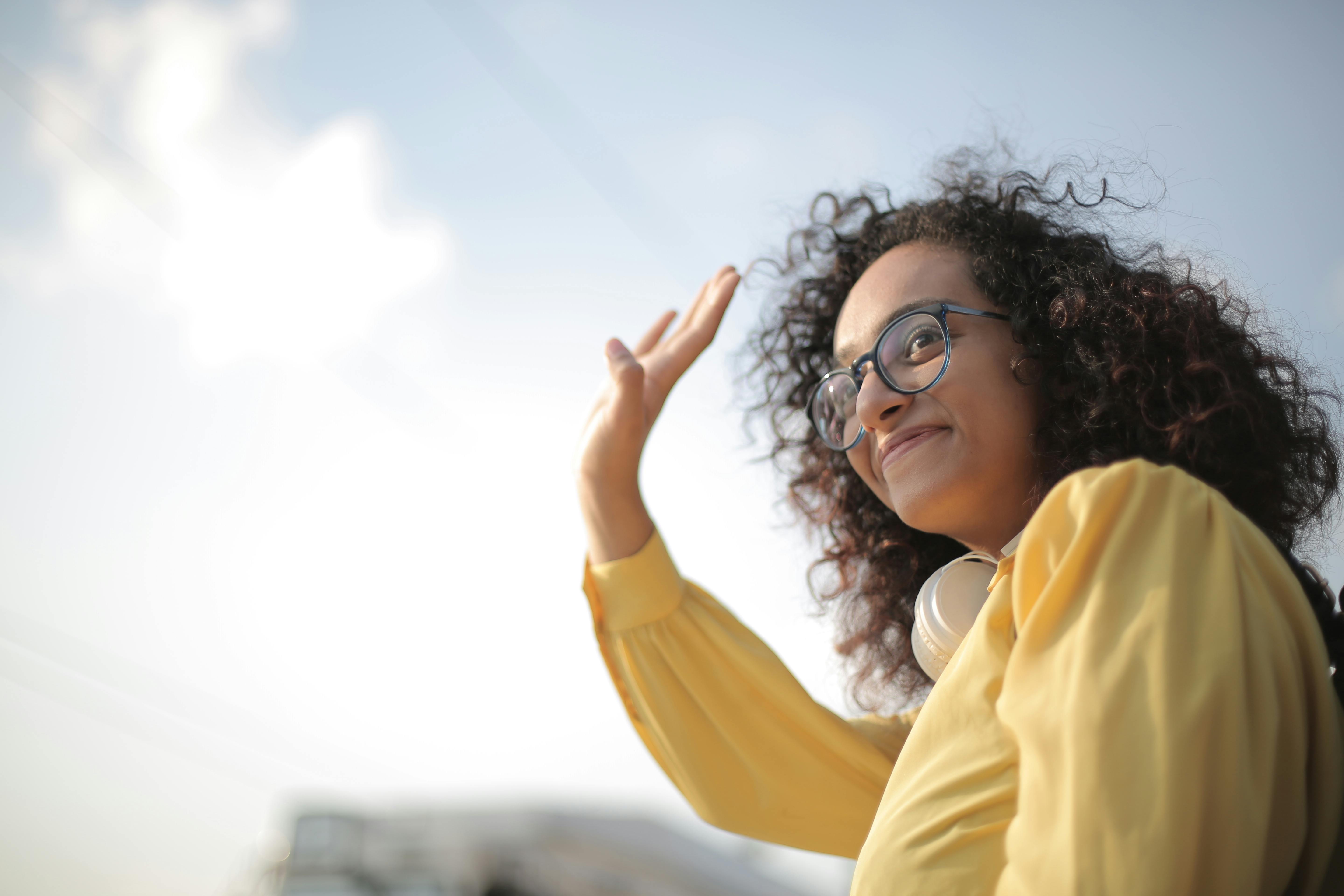 A woman waves as she passes by | Source: Pexels