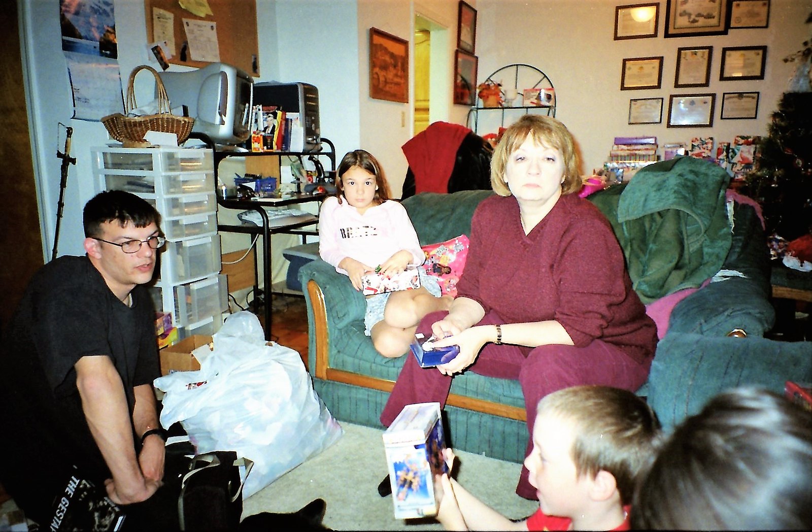 Membres d'une famille regardant leur petit garçon ouvrir son cadeau de Noël | Source : Flickr