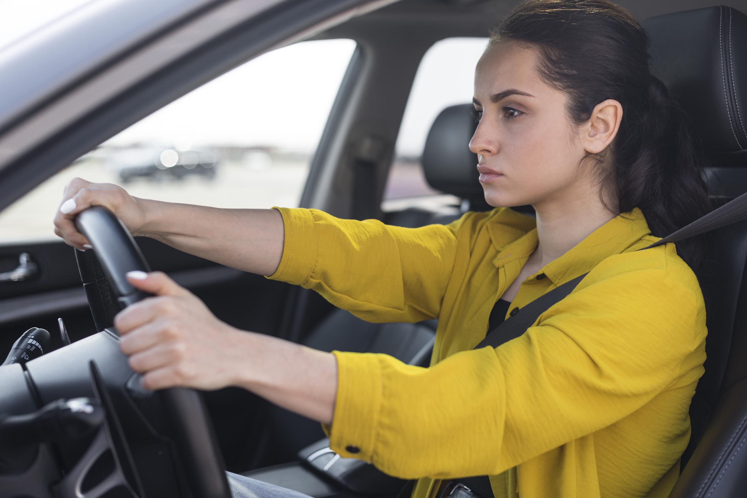 Une jeune femme frustrée au volant d'une voiture | Source : Freepik