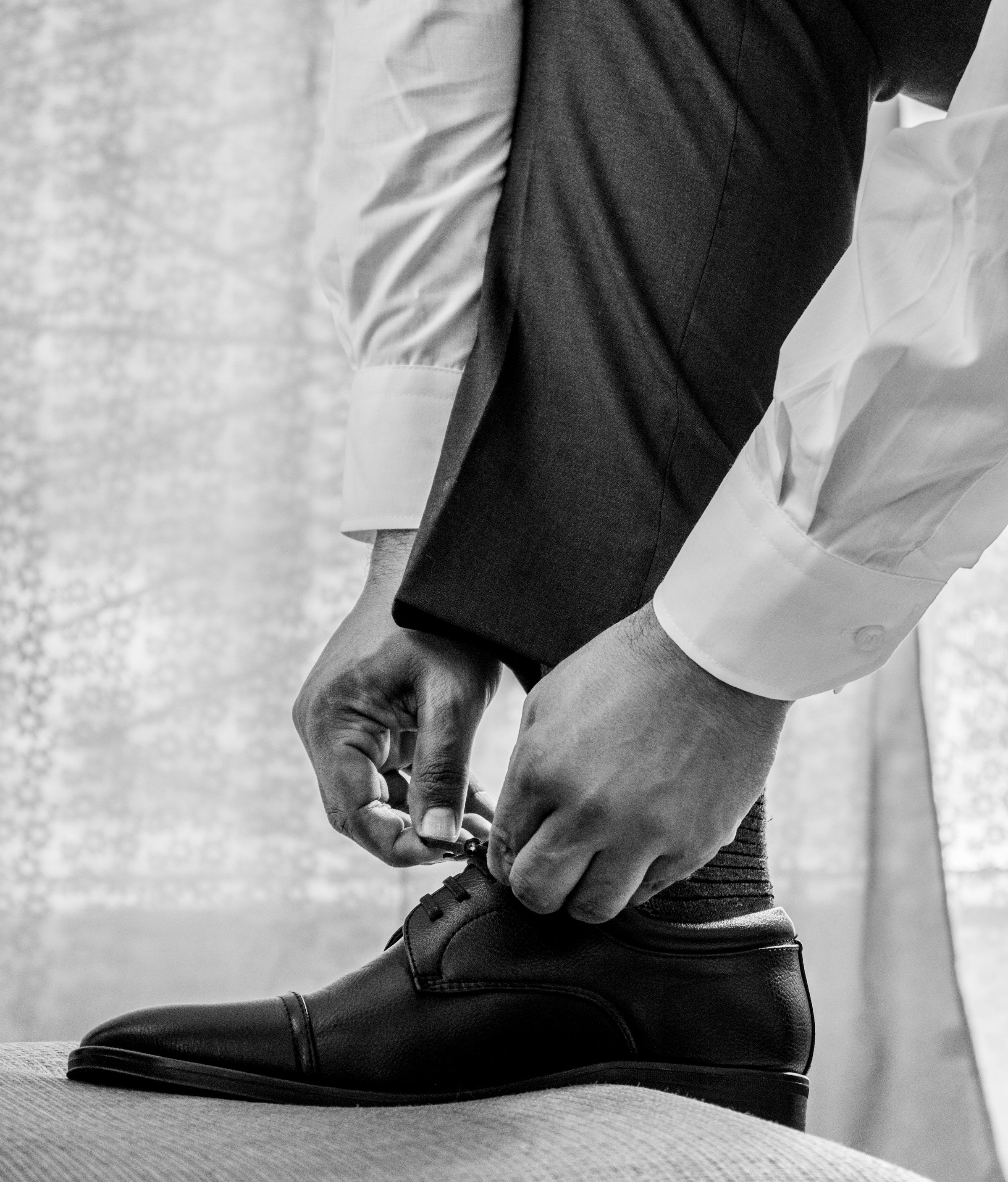 Gros plan sur un homme vêtu d'une chemise blanche et d'un pantalon noir et portant des chaussures en cuir noir | Source : Unsplash