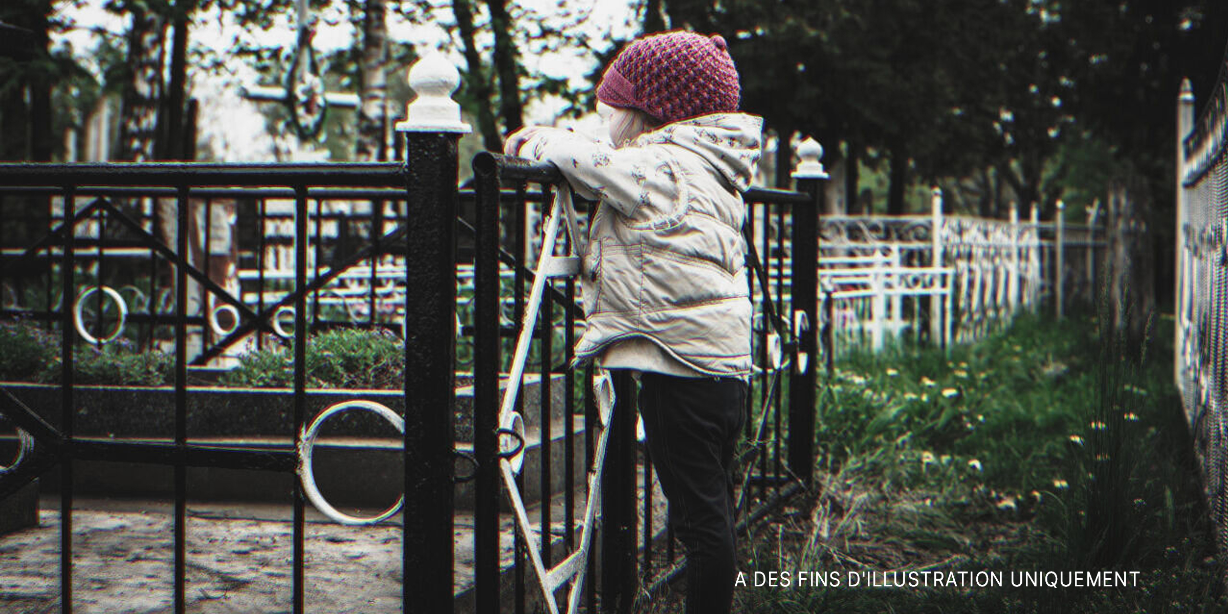 Petite fille debout près d'une clôture | Source : Shutterstock