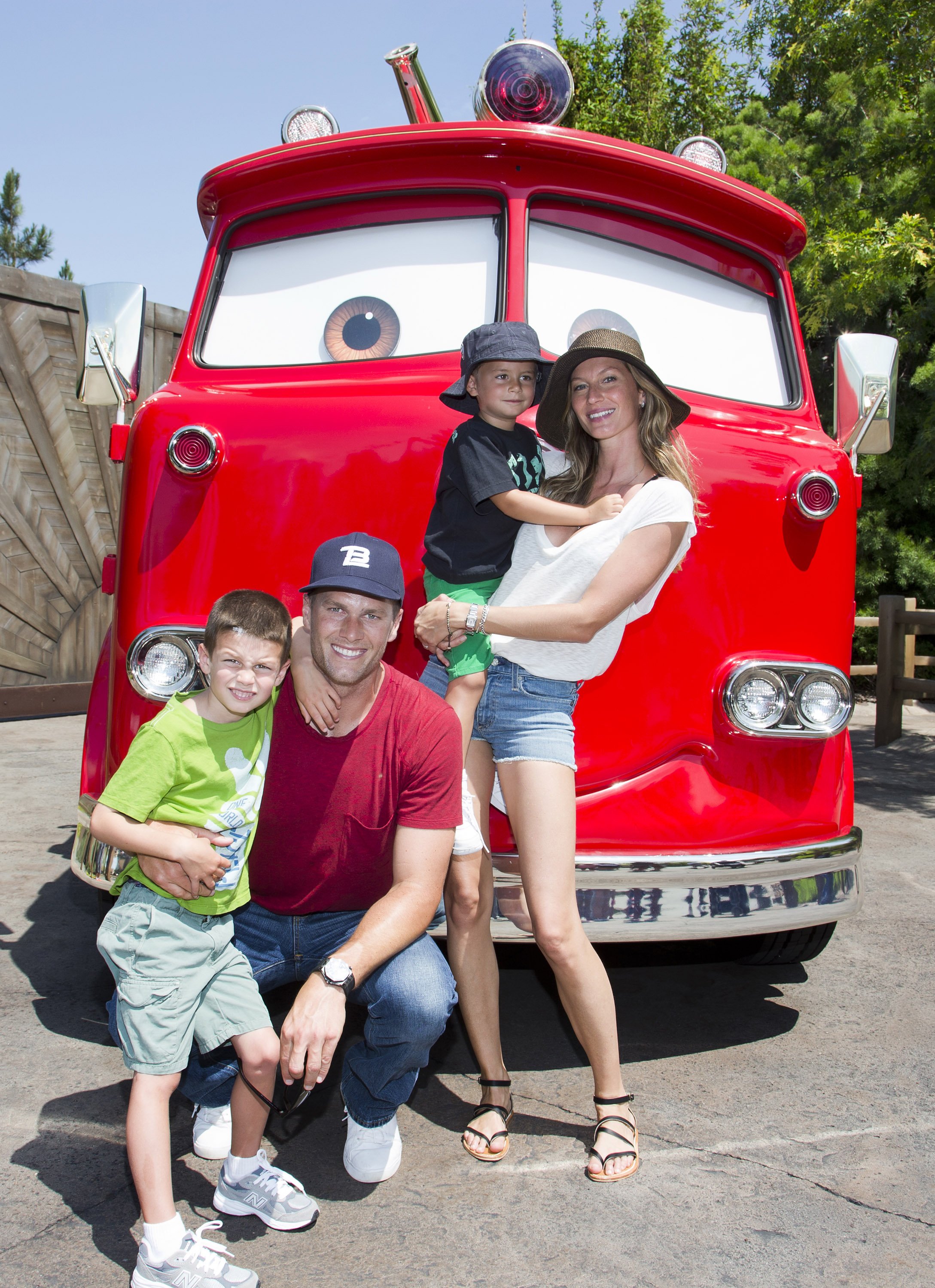 Tom Brady, son fils Jack, 5 ans, Gisele Bundchen, et leur fils Benjamin, 3 ans, posent avec Red the Fire Truck à Cars Land au parc Disney California Adventure | Source: Getty Images