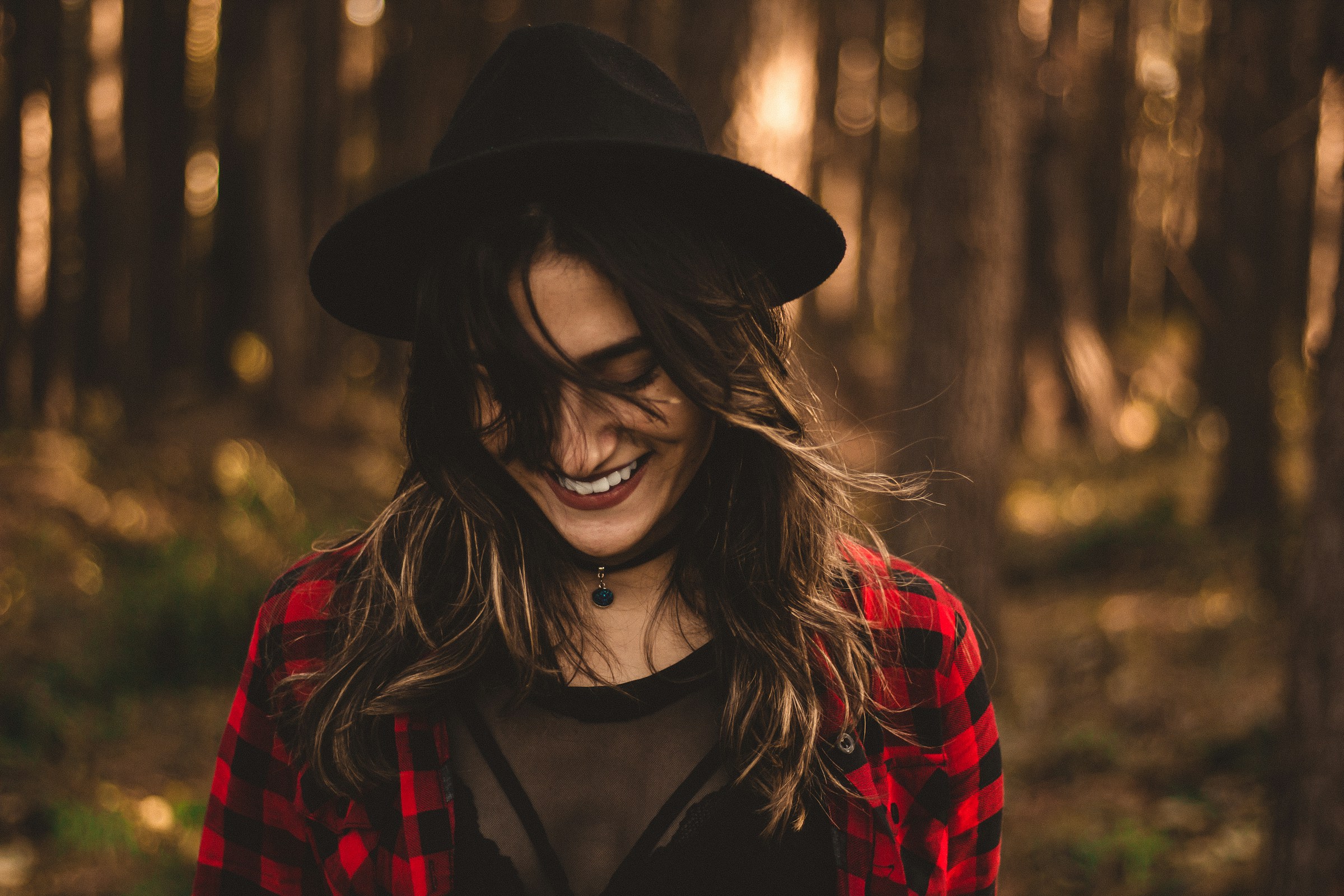 Une femme souriant dans la forêt | Source : Unsplash