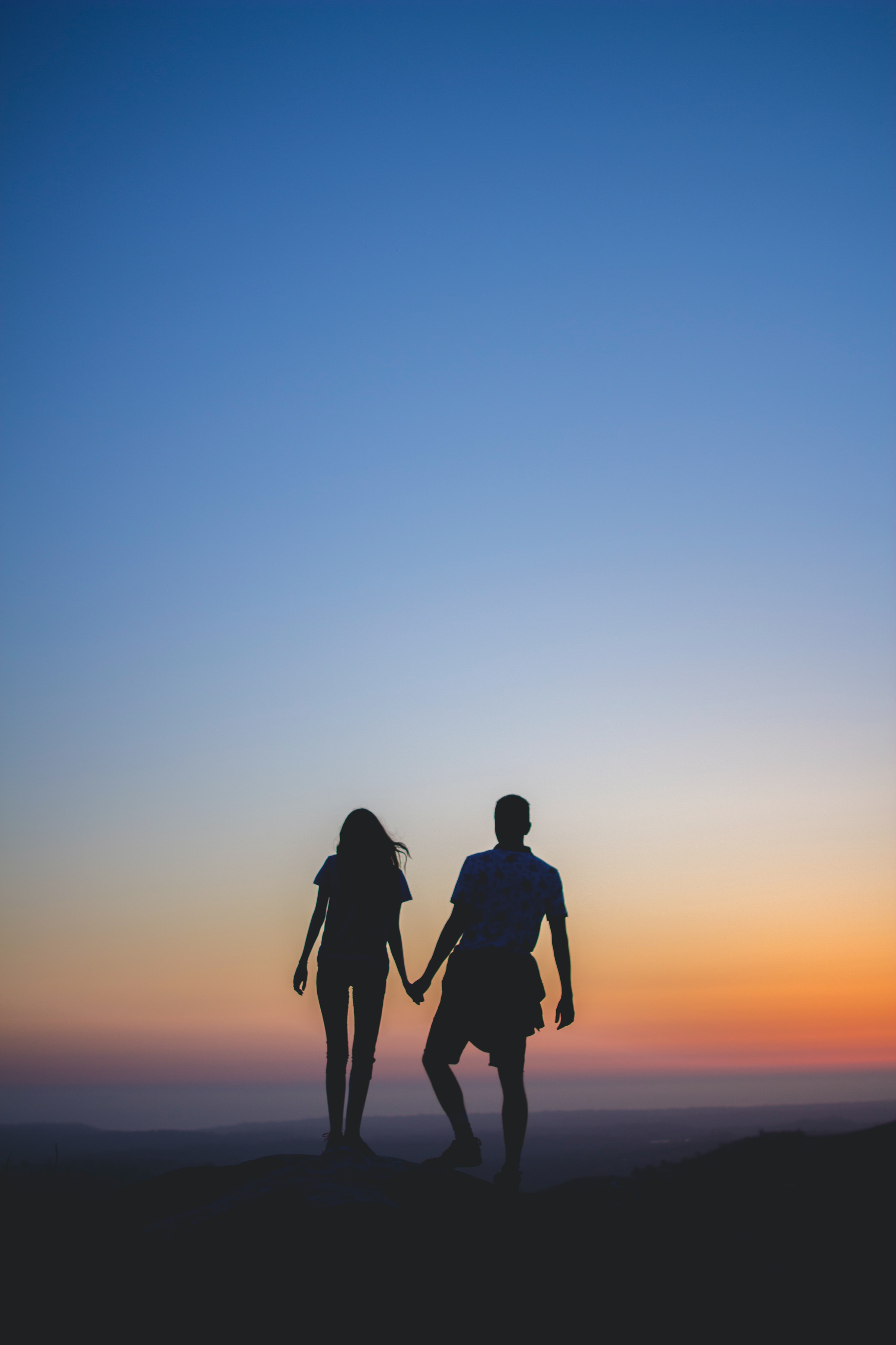 Silhouette d'un couple se tenant par la main | Source : Unsplash