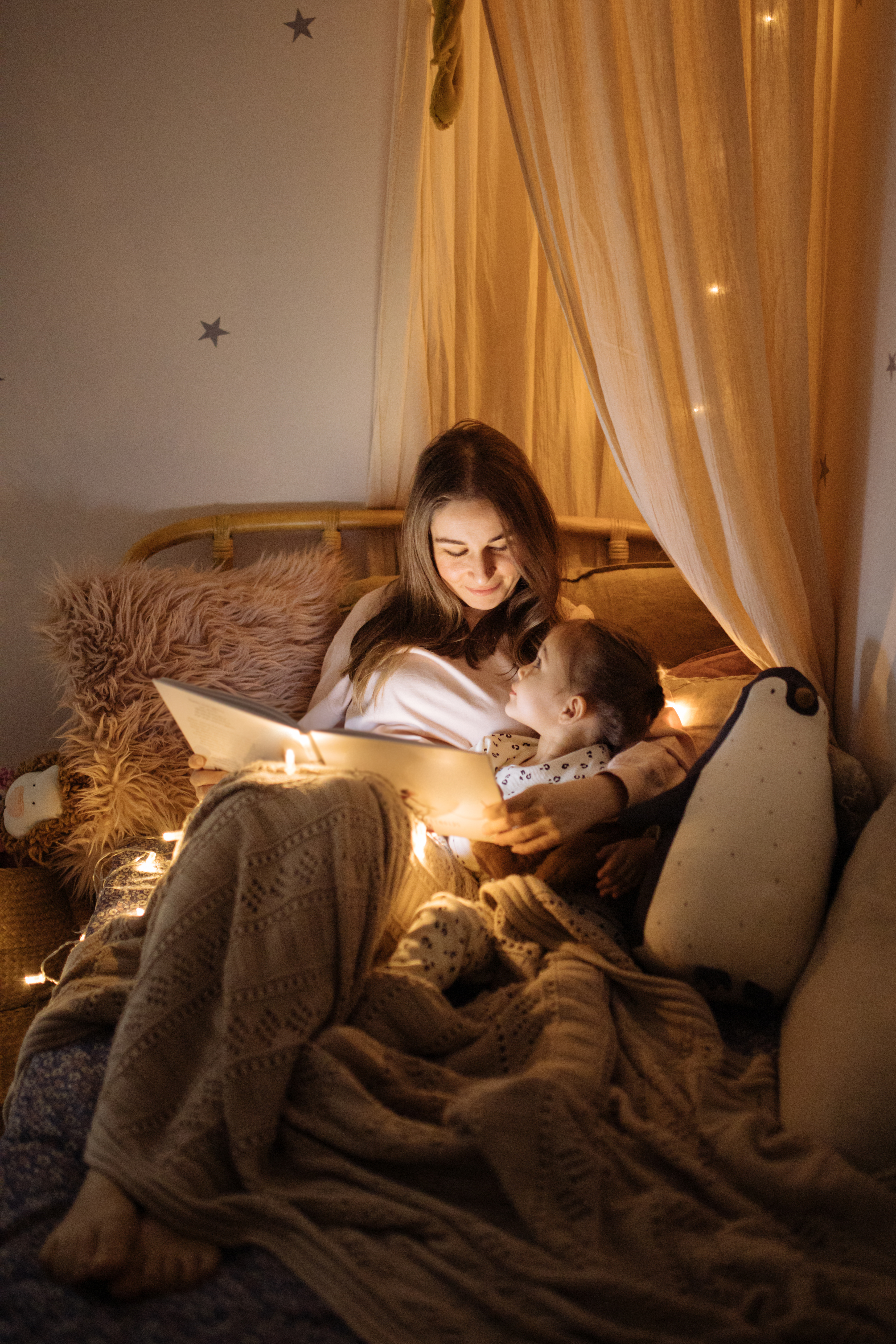 Mère et enfant lisant un livre au lit avant de s'endormir | Source : Getty Images