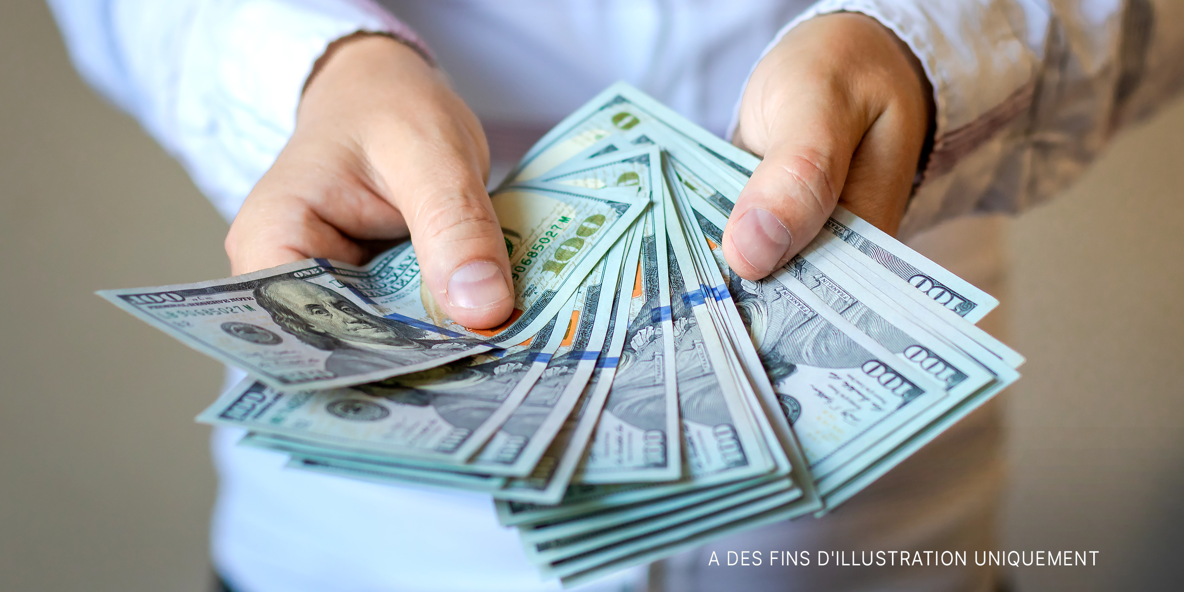 Une personne tenant des billets de banque | Source : Shutterstock