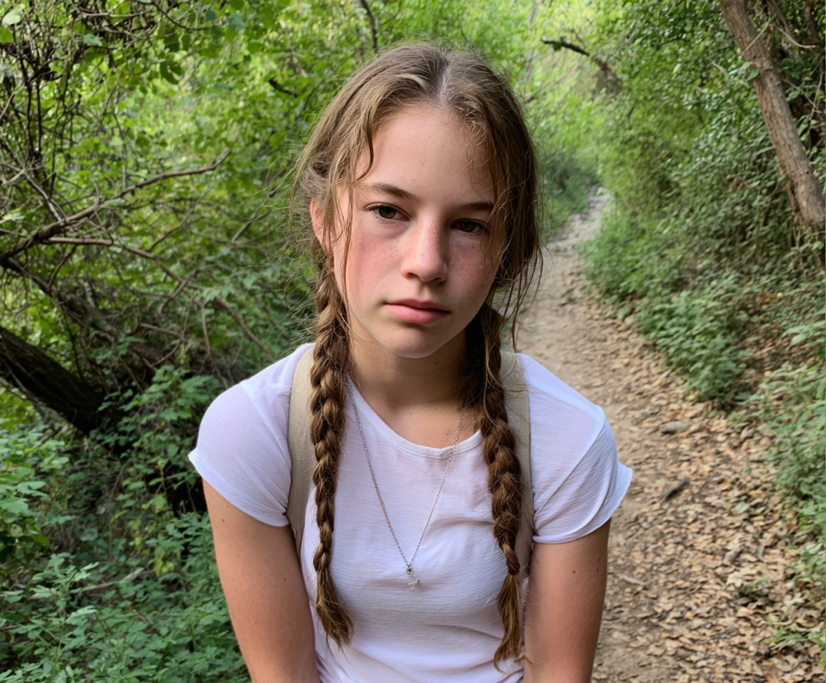 Une adolescente stressée portant un t-shirt blanc lors d'une randonnée | Source : Midjourney