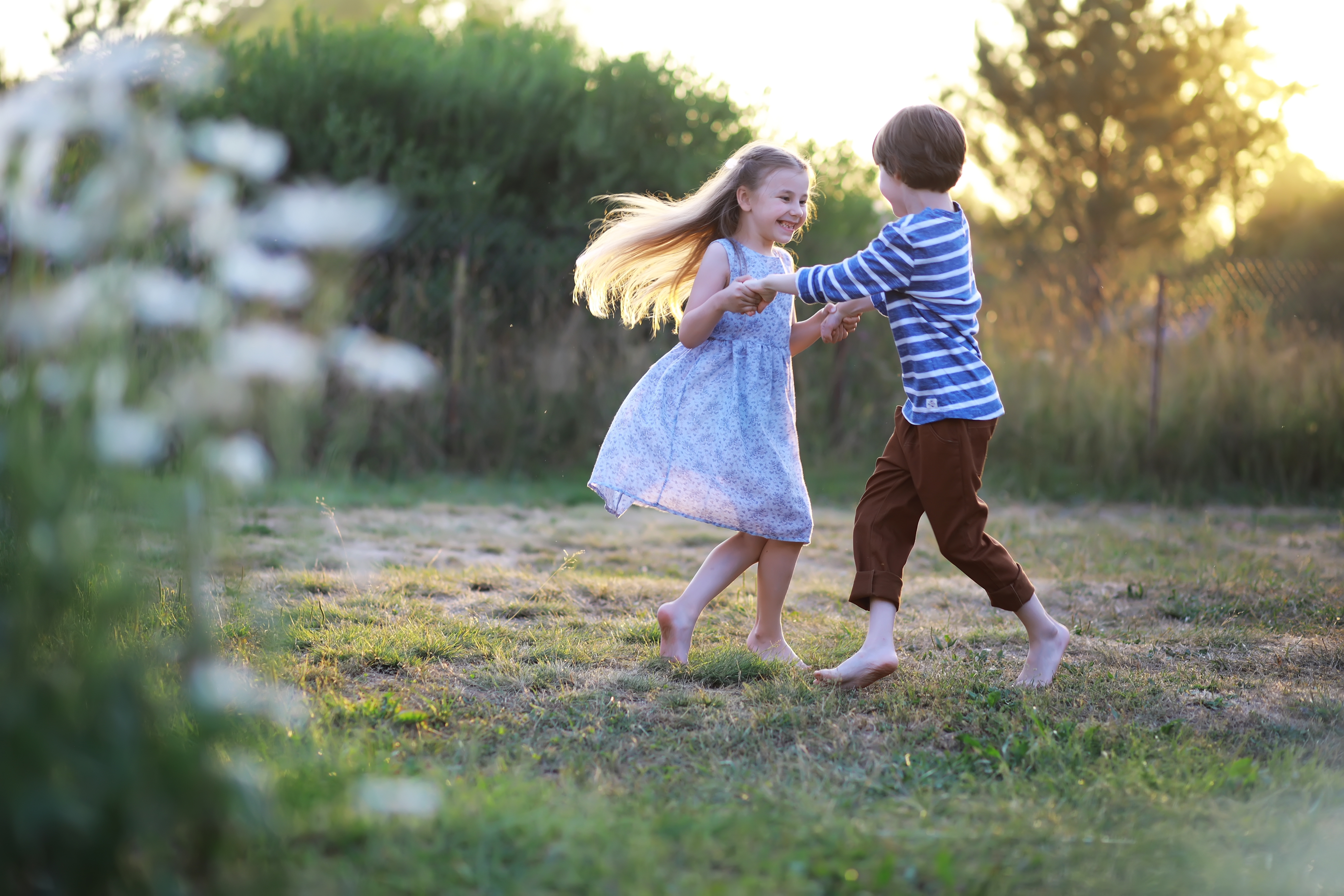 Un jeune garçon est photographié en train de jouer avec une jeune fille dans le parc | Source : Shutterstock