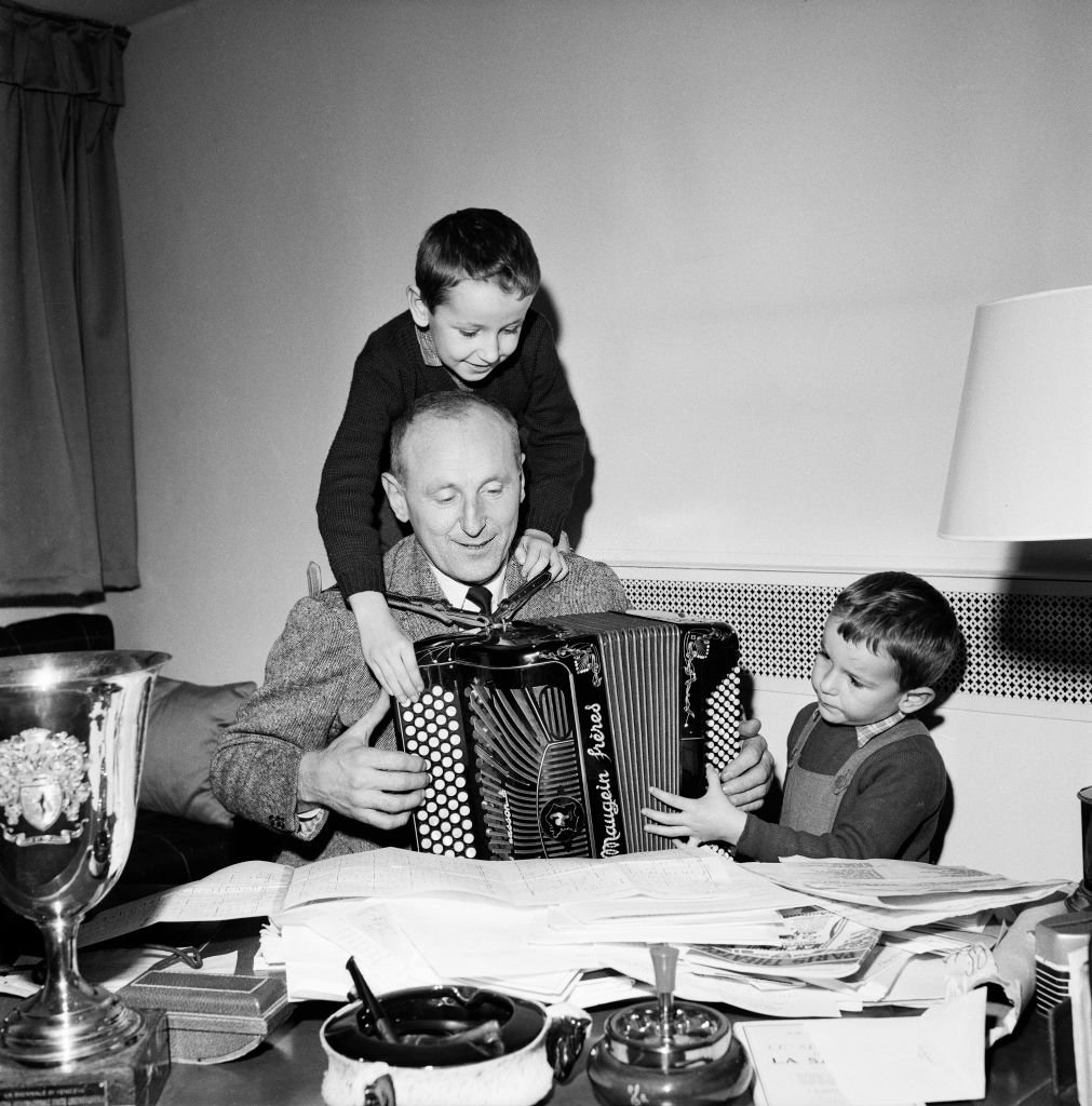 L'acteur français Bourvil à l'accordéon, entouré de ses fils Dominique et Philippe. | Photo : Getty Images. | Photo : Getty Images