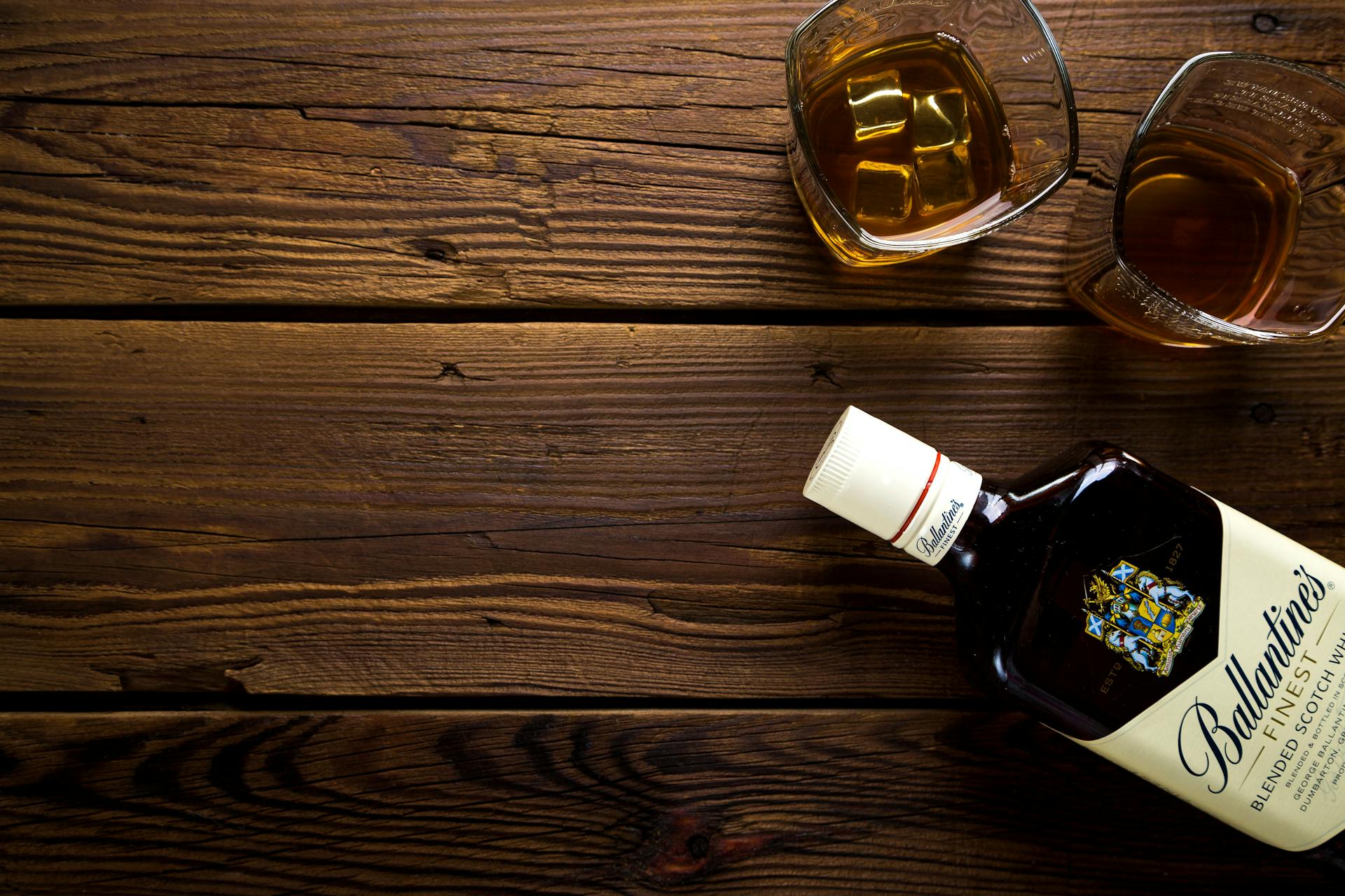 Deux verres et une bouteille d'alcool sur une table | Source : Pexels