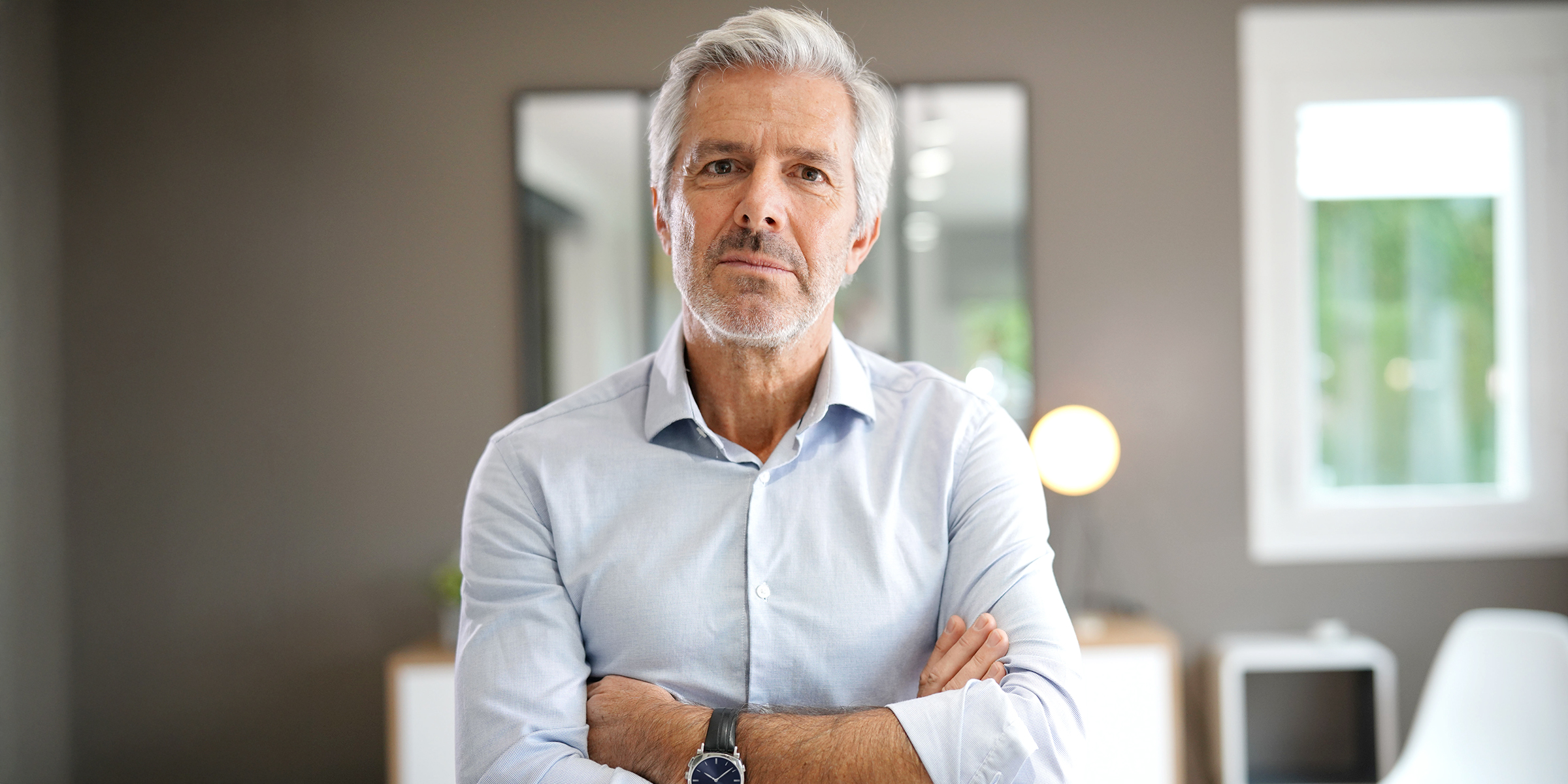 Un homme debout avec les bras croisés | Source : Shutterstock