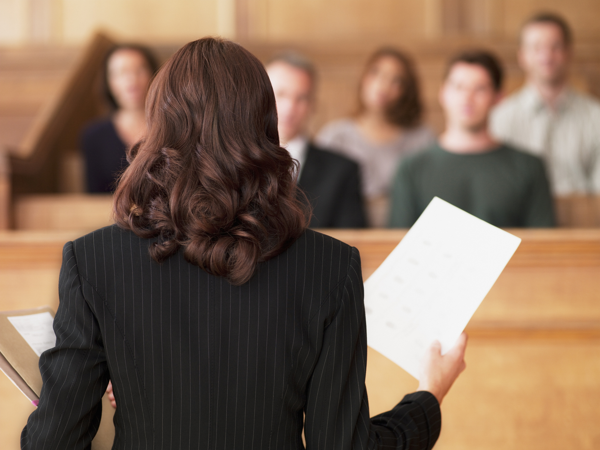 Avocat tenant un document et s'adressant au jury dans une salle d'audience I Photo d'illustration I Source : Getty Images