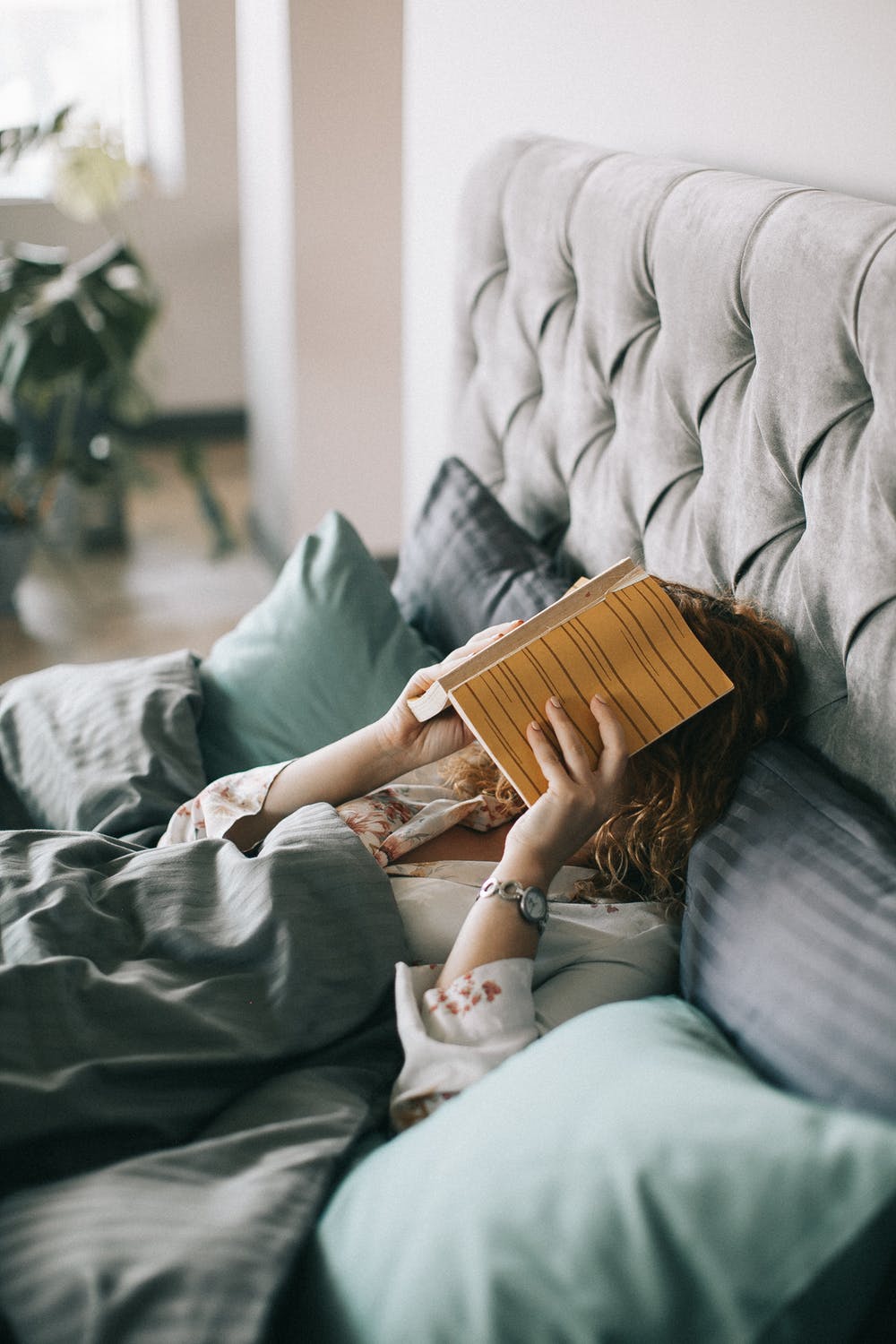 Une femme lisant un livre dans son lit. l Source: Pexels