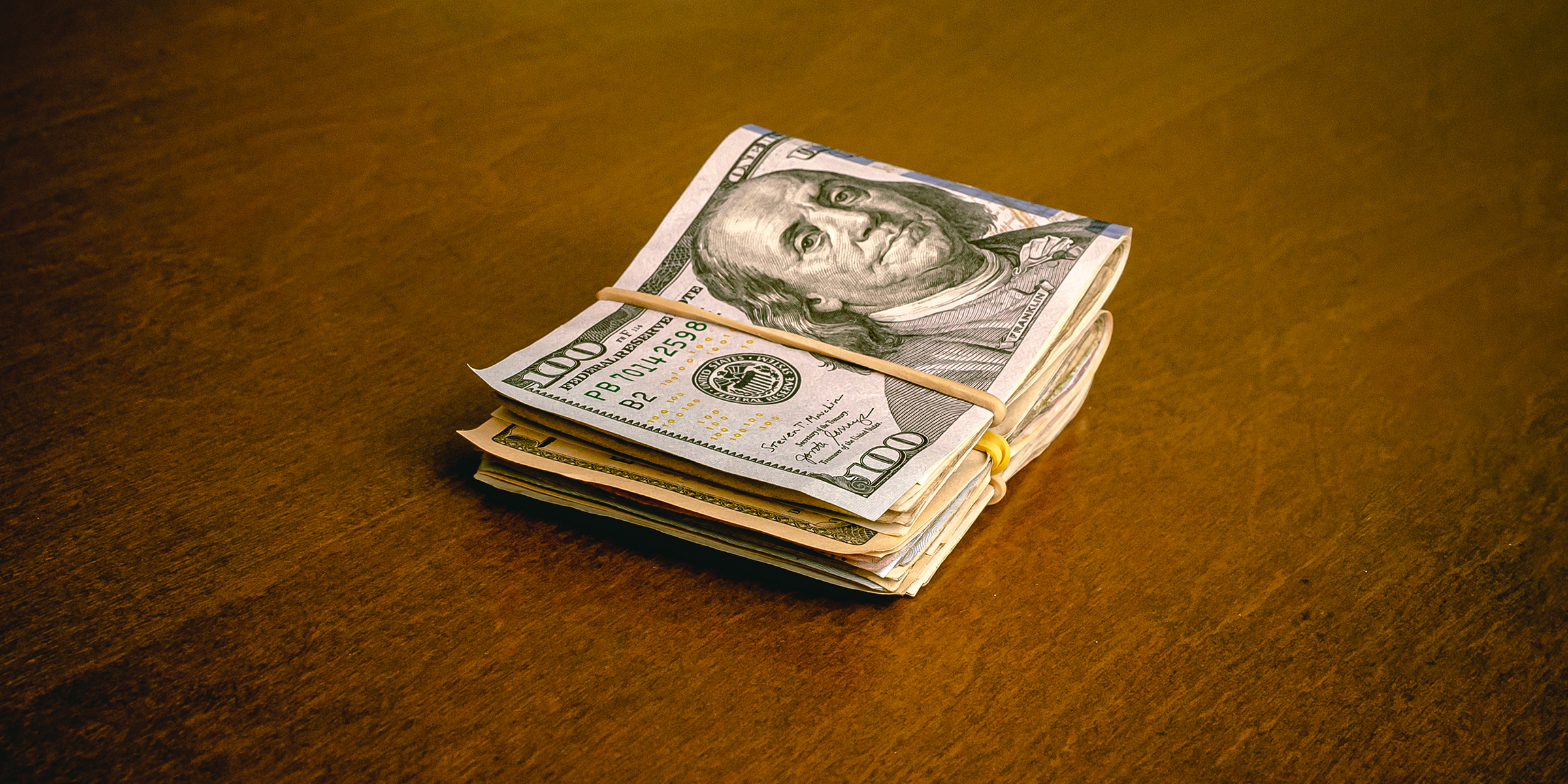 Une pile de billets de banque pliés sur une table | Source : Shutterstock