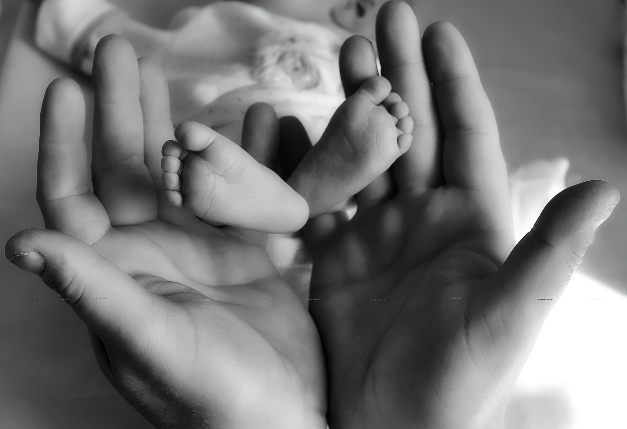 Une femme tenant les pieds d'un nouveau-né | Source : Pixabay
