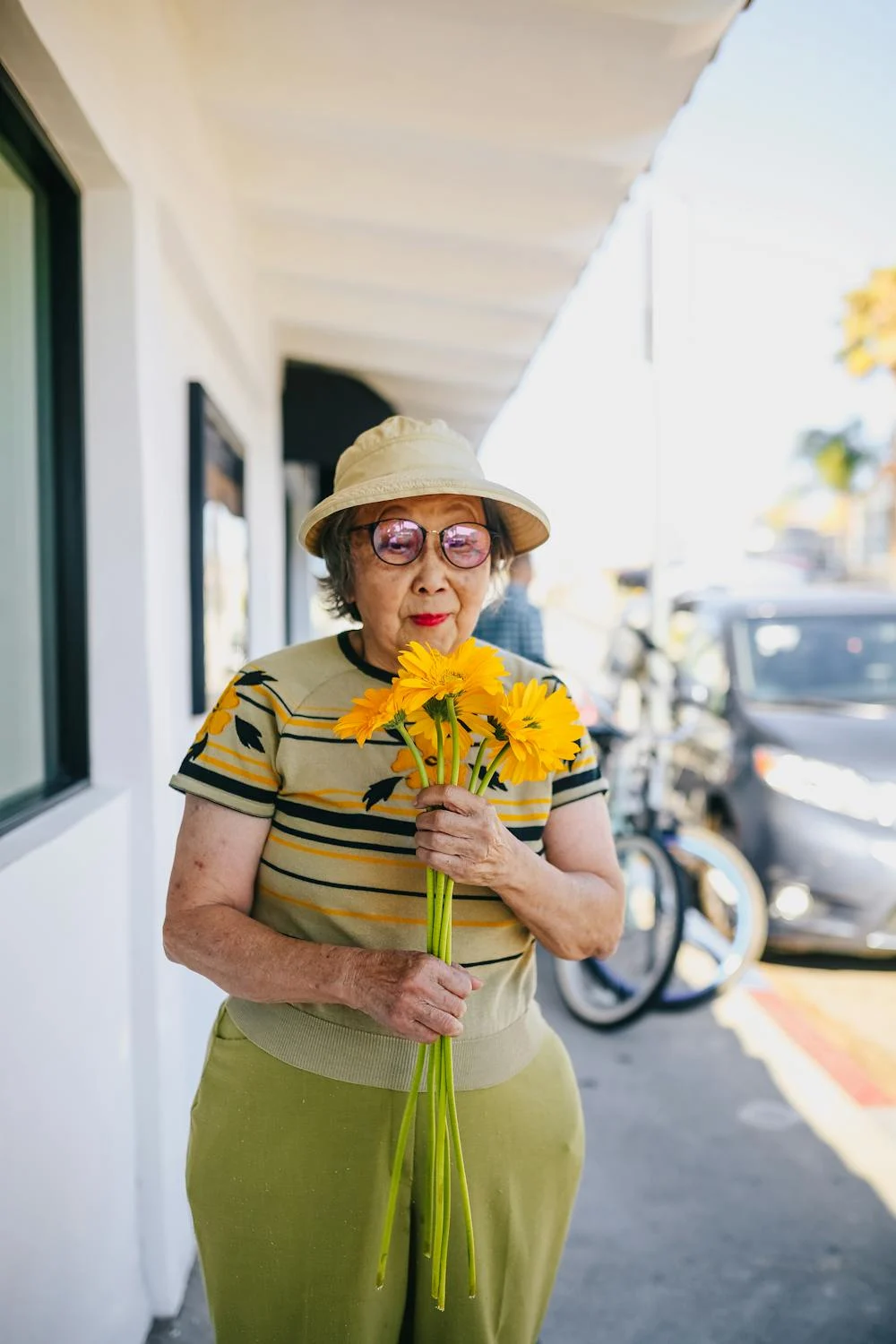 Une femme âgée souriante tenant des fleurs | Source : Pexels