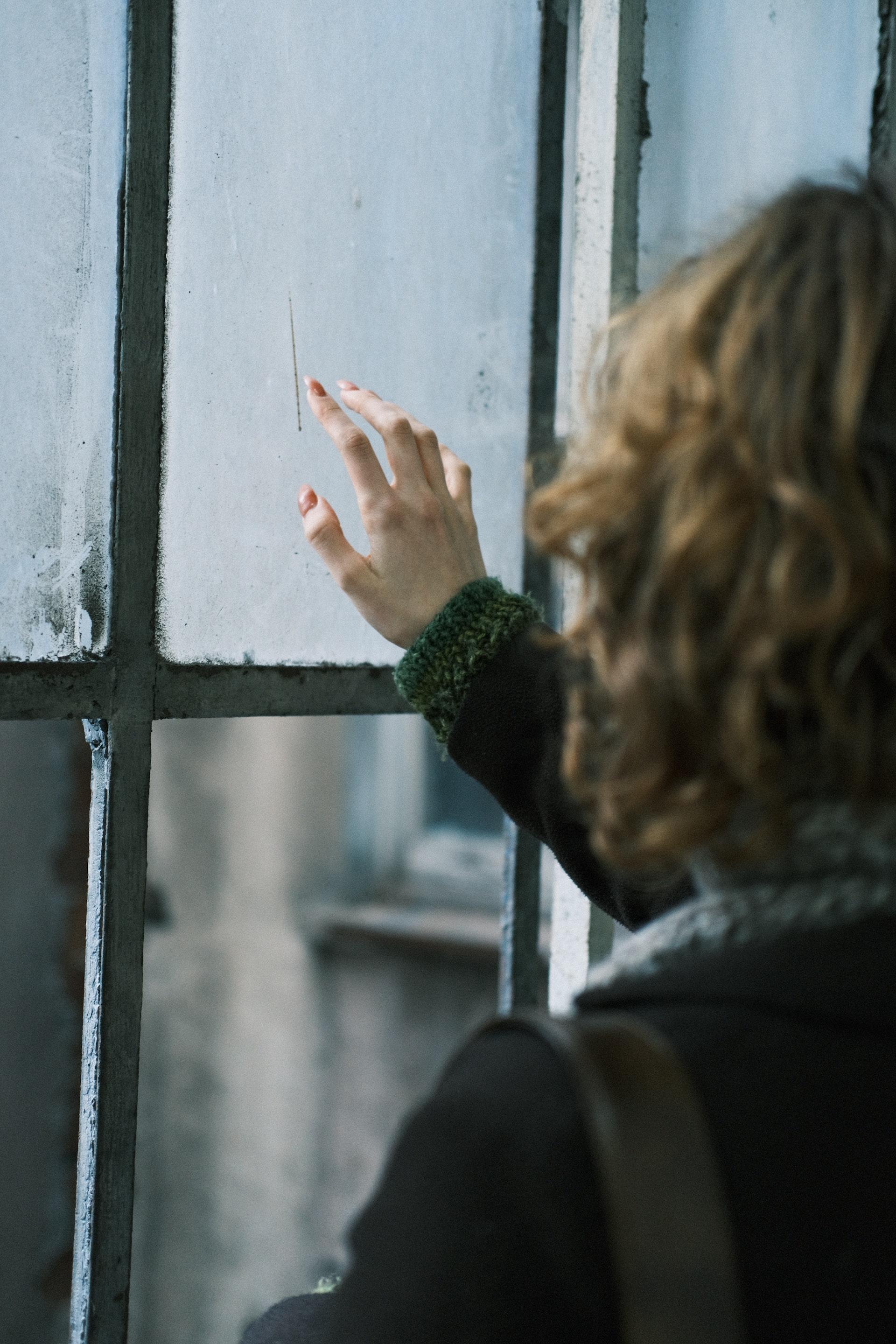 Une femme touchant une fenêtre en verre | Source : Pexels