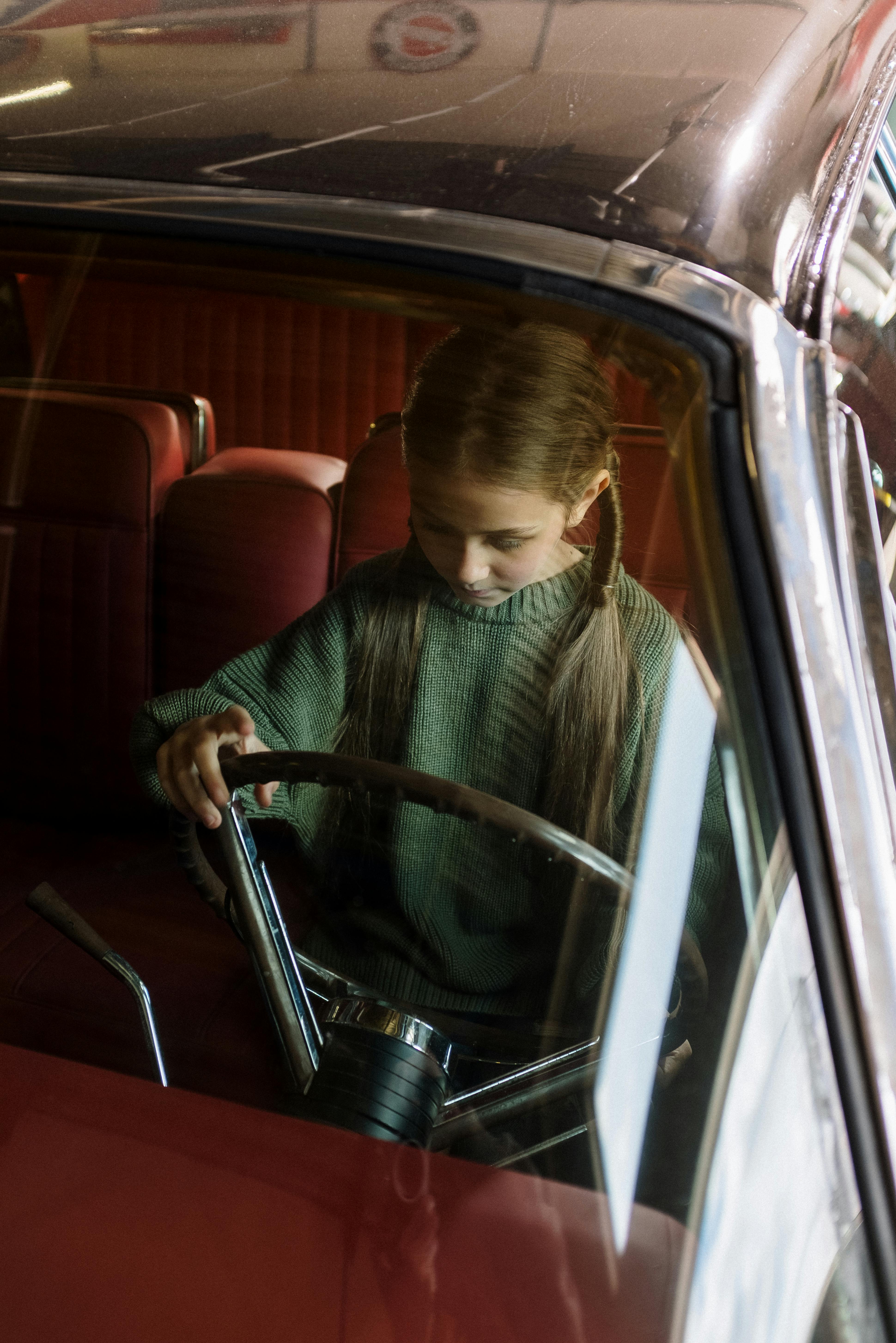 Une petite fille qui joue dans une voiture garée | Source : Pexels