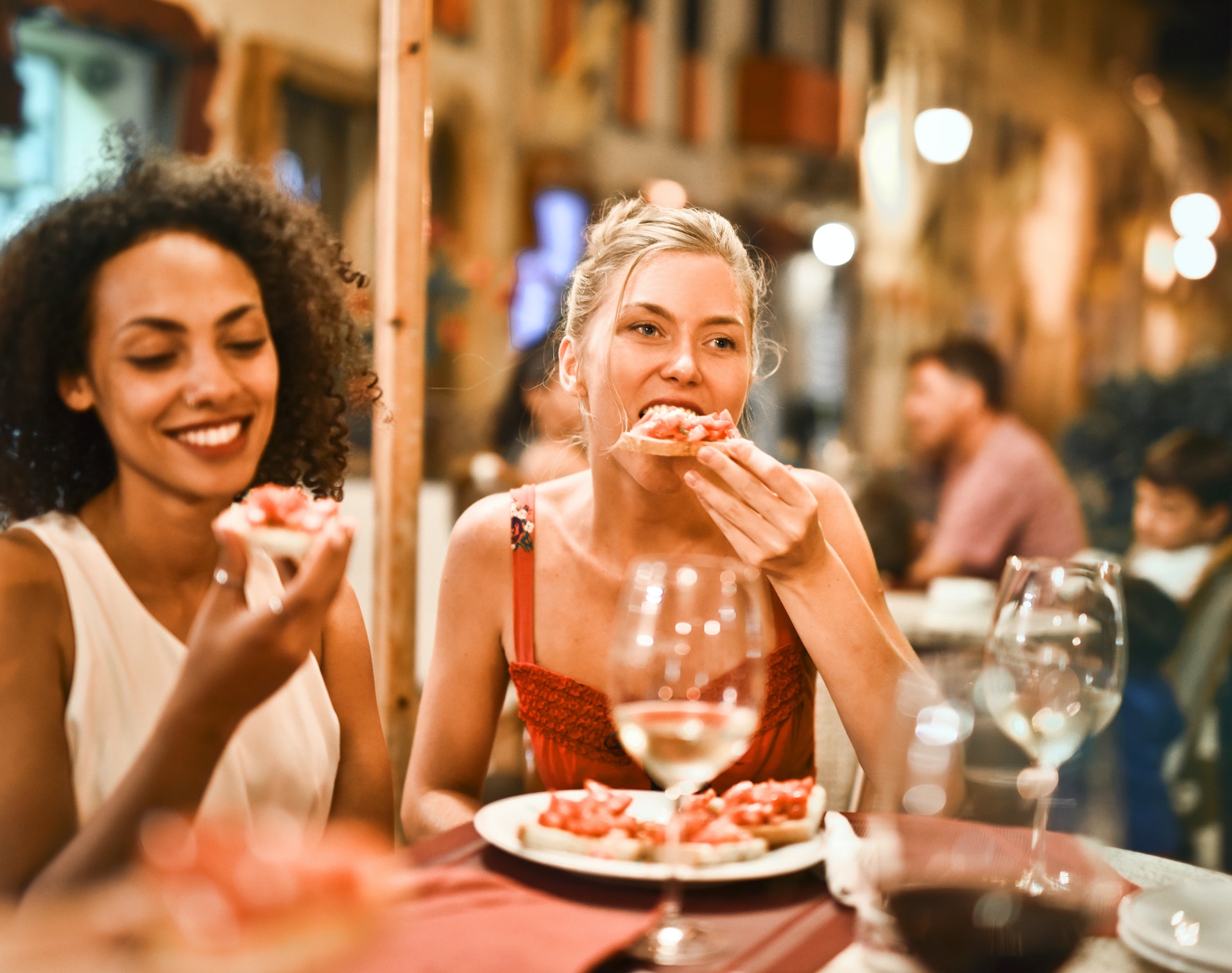 Des femmes mangeant et buvant des boissons dans un restaurant | Source : Pexels