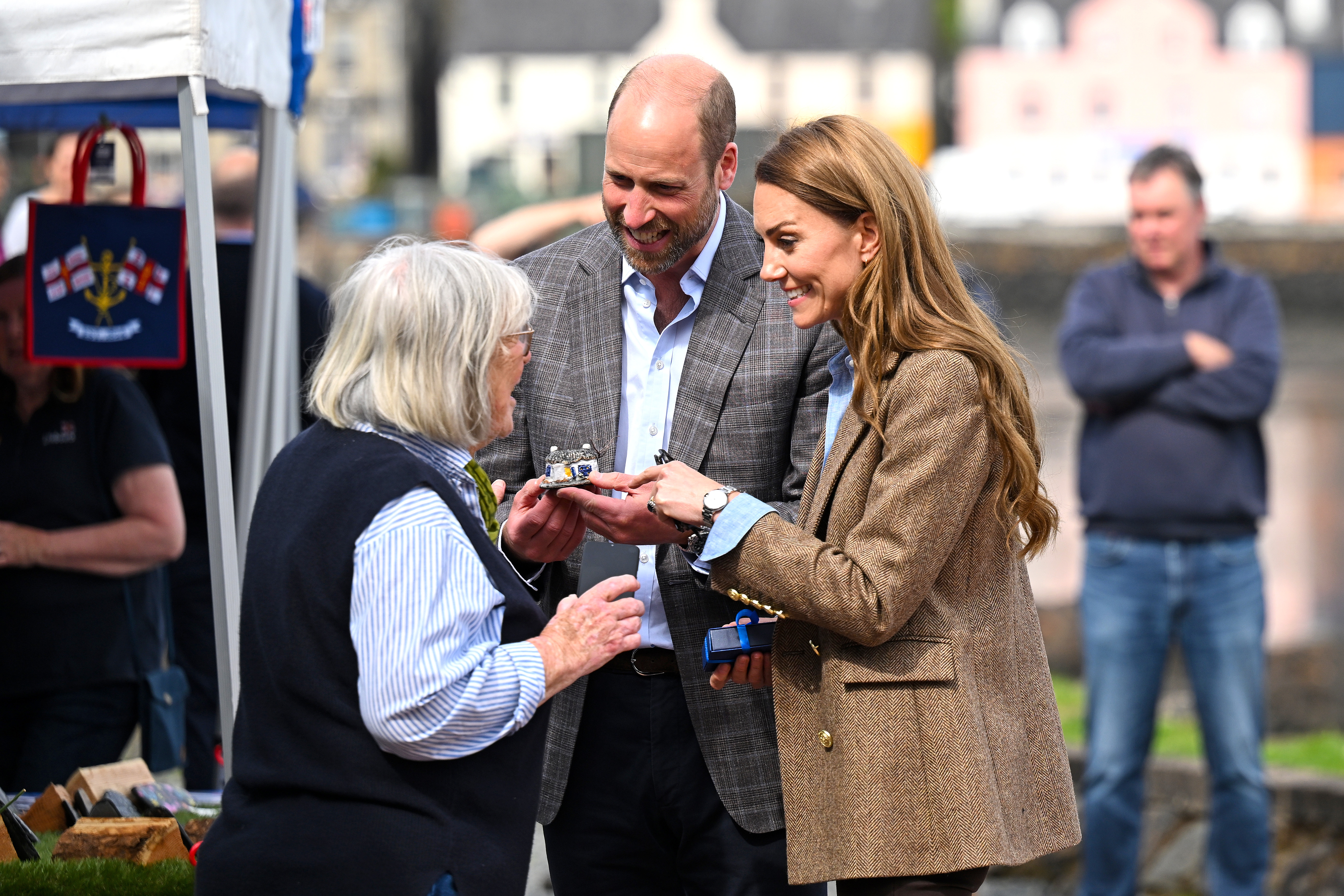 William et Catherine échangent avec une vendeuse du marché local lors de leur promenade à Tobermory. Lors de leur visite sur l'île de Mull, ils ont mis l'accent sur le soutien aux petites entreprises et sur la participation à des travaux environnementaux menés par la communauté.