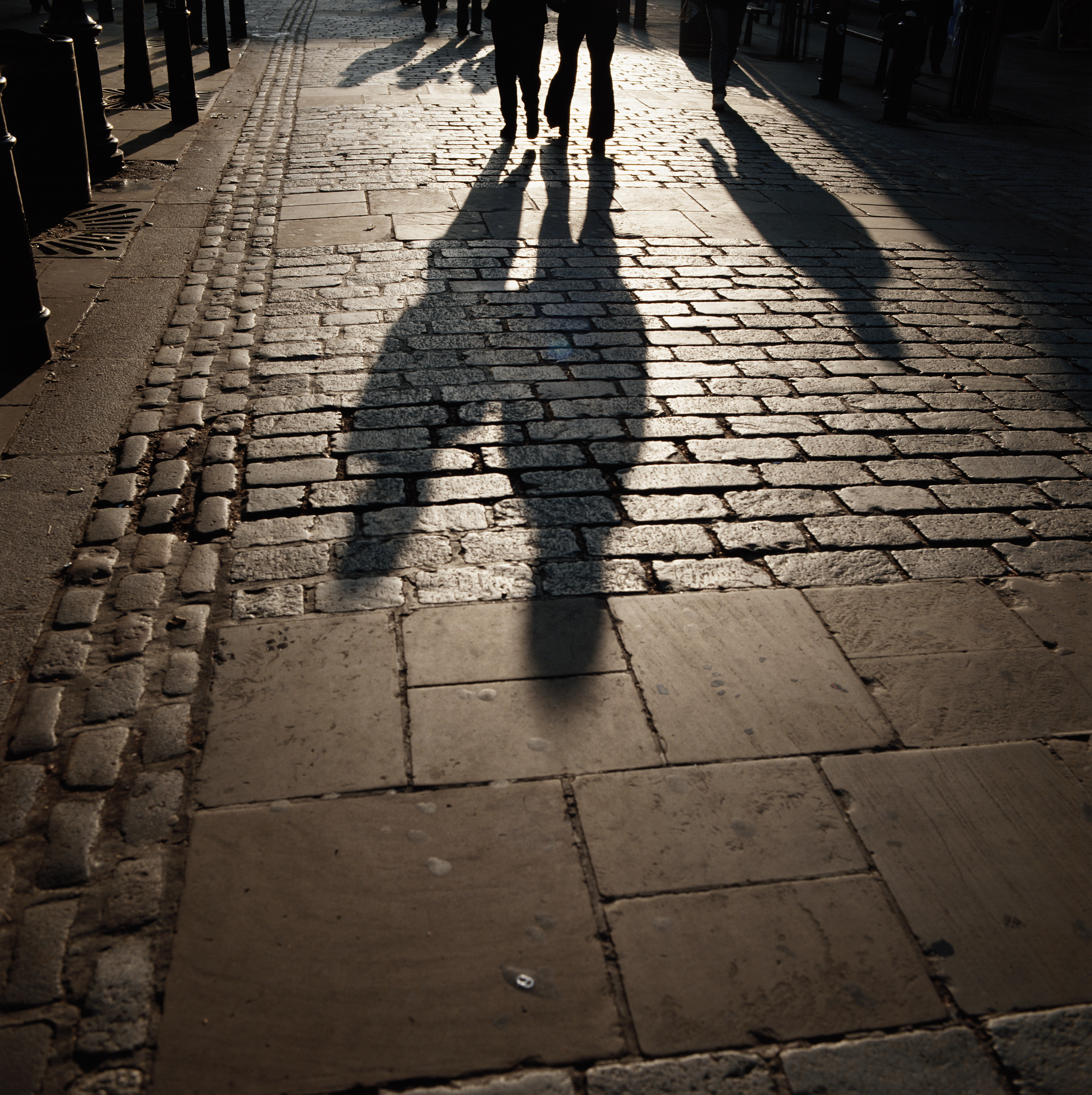 Ombre de personnes marchant sur un chemin piétonnier | Source : Getty Images