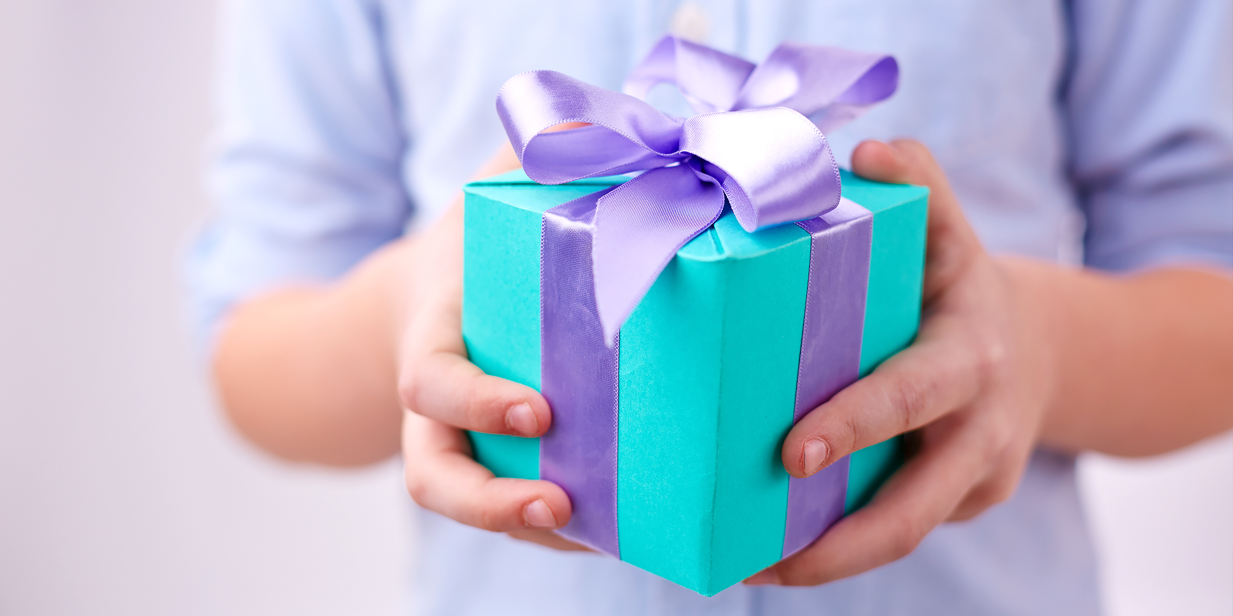 Garçon tenant une boîte de cadeaux | Source : Shutterstock