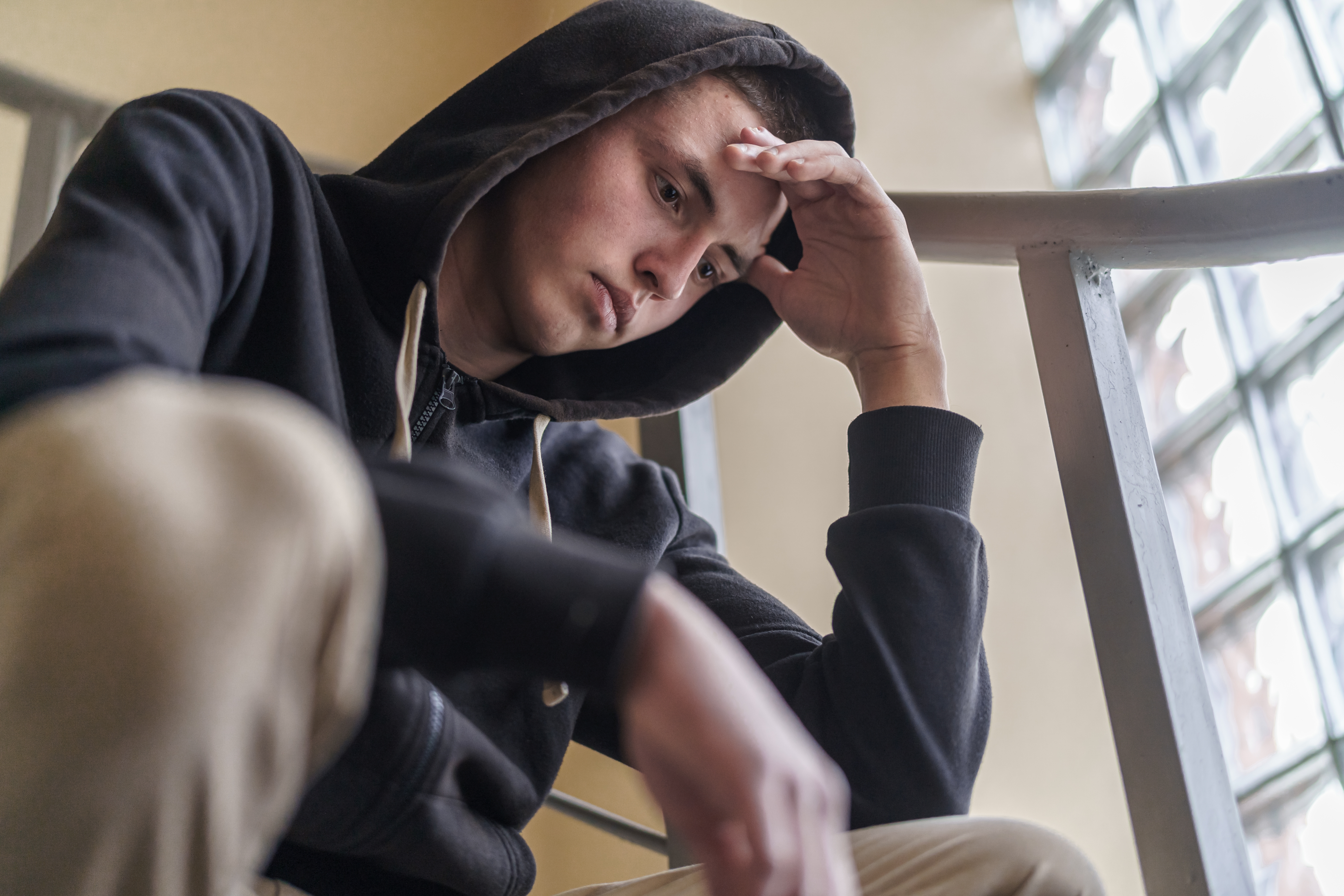 Un jeune homme portant un sweat à capuche, l'air troublé | Source : Shutterstock