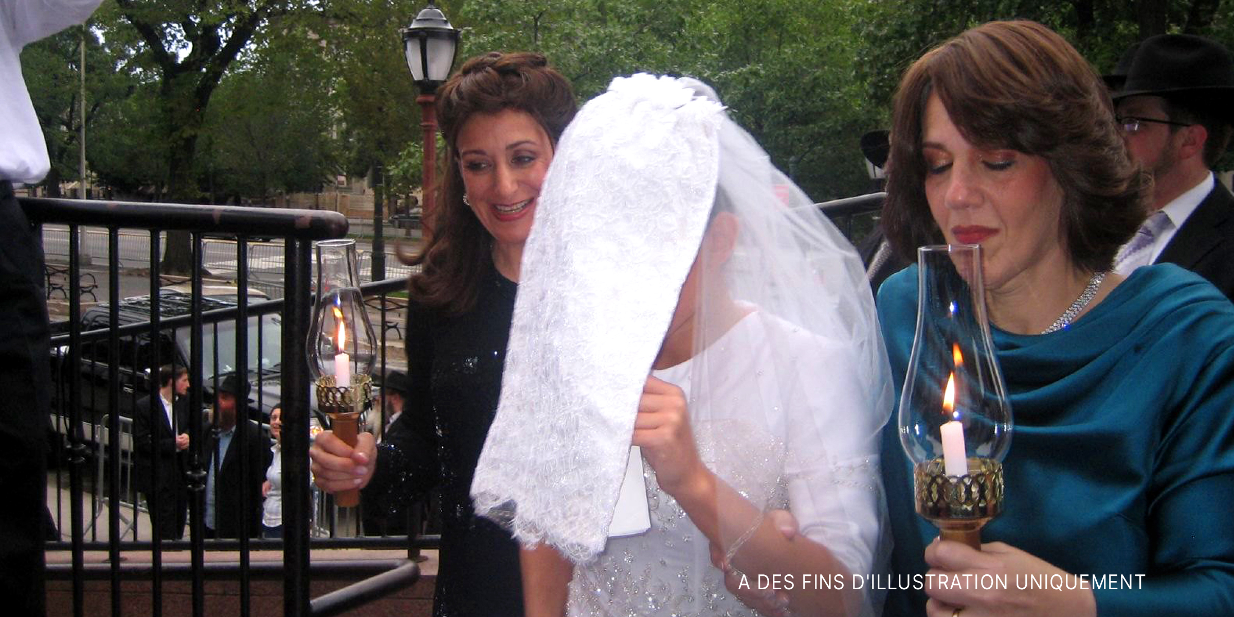 Une mariée escortée par deux femmes tenant des lampes | Source : Flickr.com/goldberg/CC BY-SA 2.0