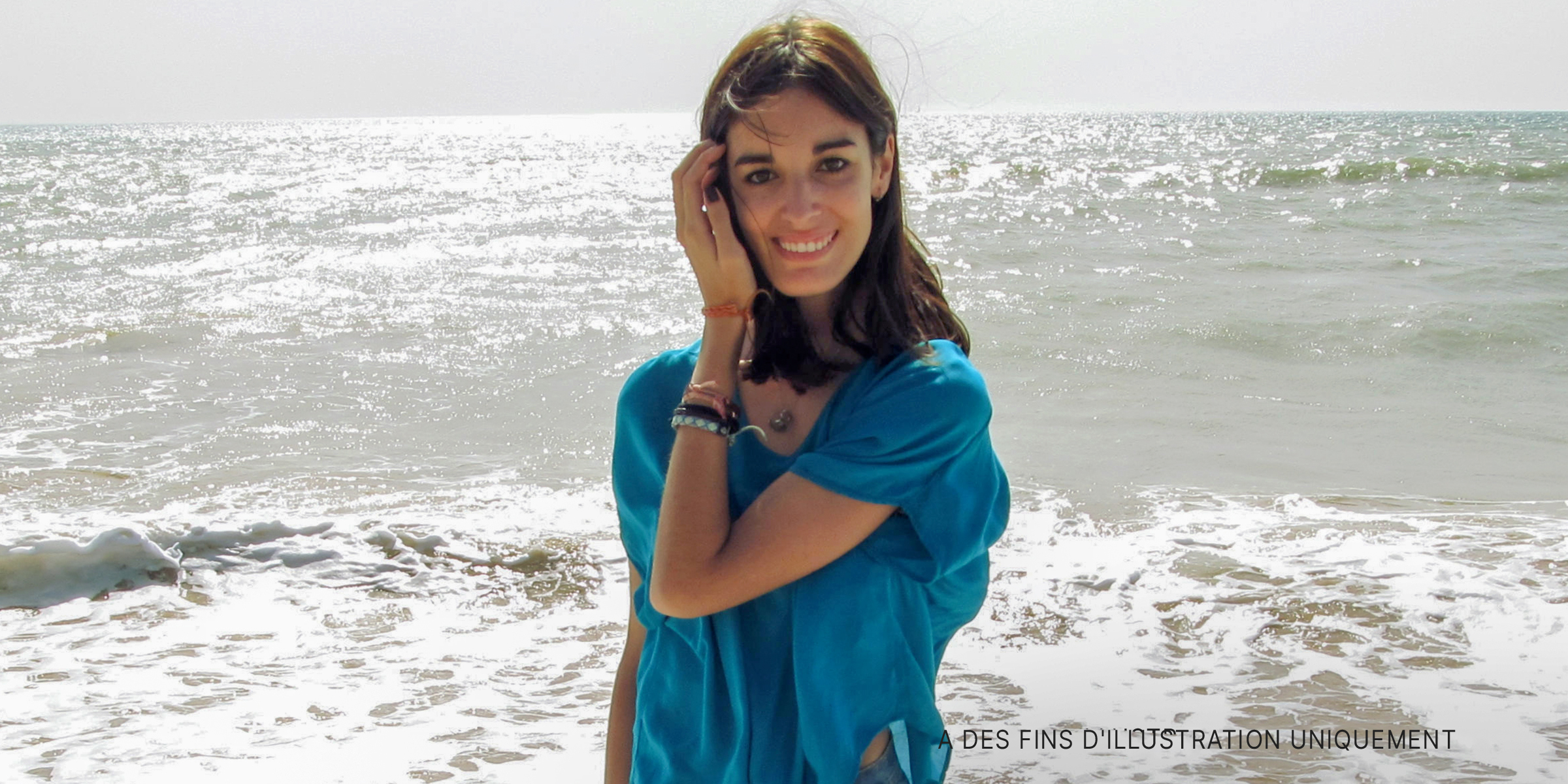 Une jeune femme sourit alors qu'elle se trouve dans l'eau sur une plage | Source : Flickr/Por mi tripa.../CC BY 2.0