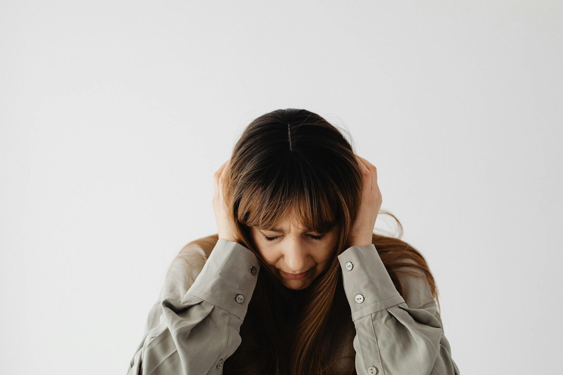 Une femme triste assise, la tête dans les mains | Source : Pexels