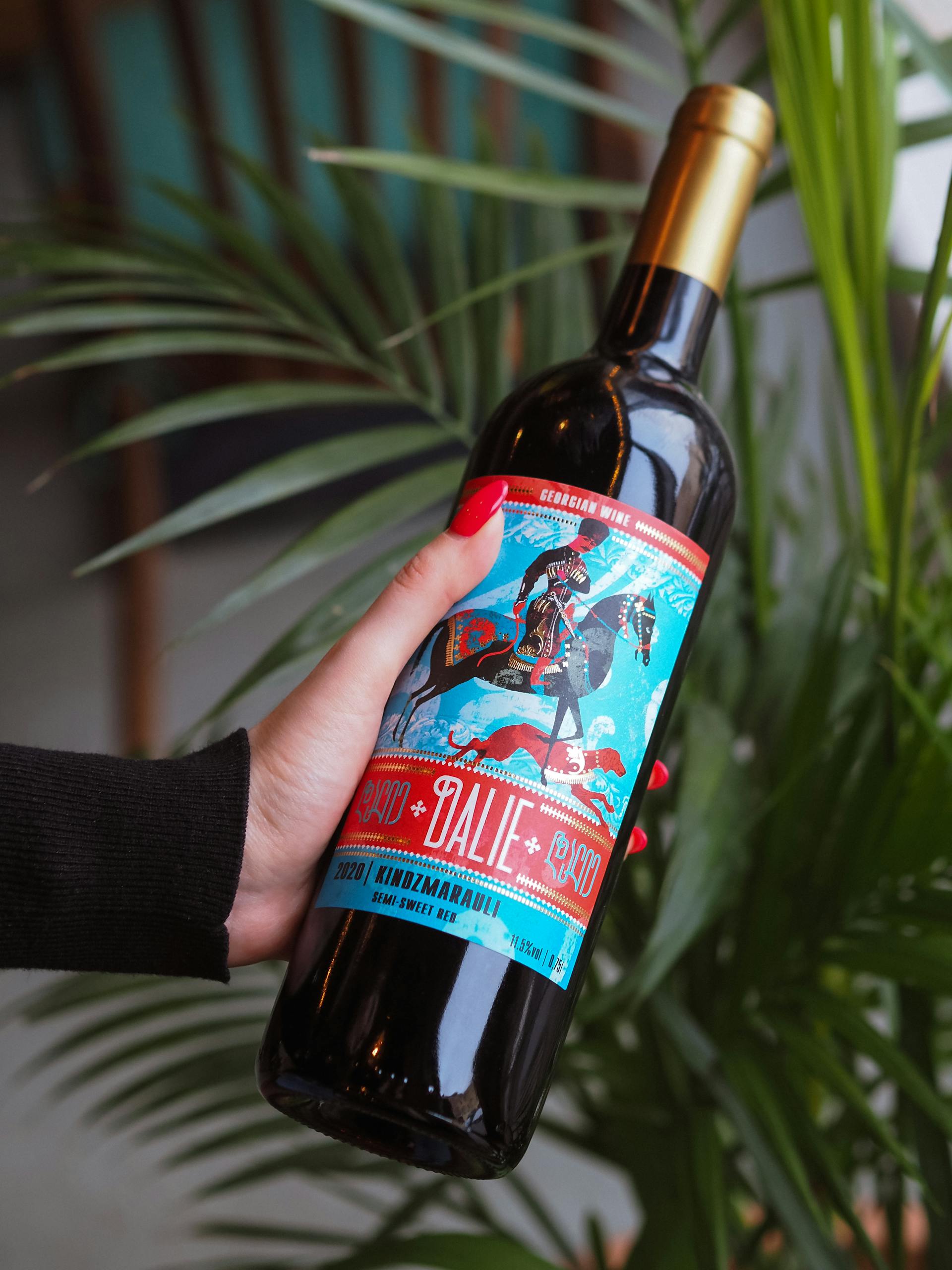 Gros plan sur une femme tenant une bouteille de vin | Source : Pexels
