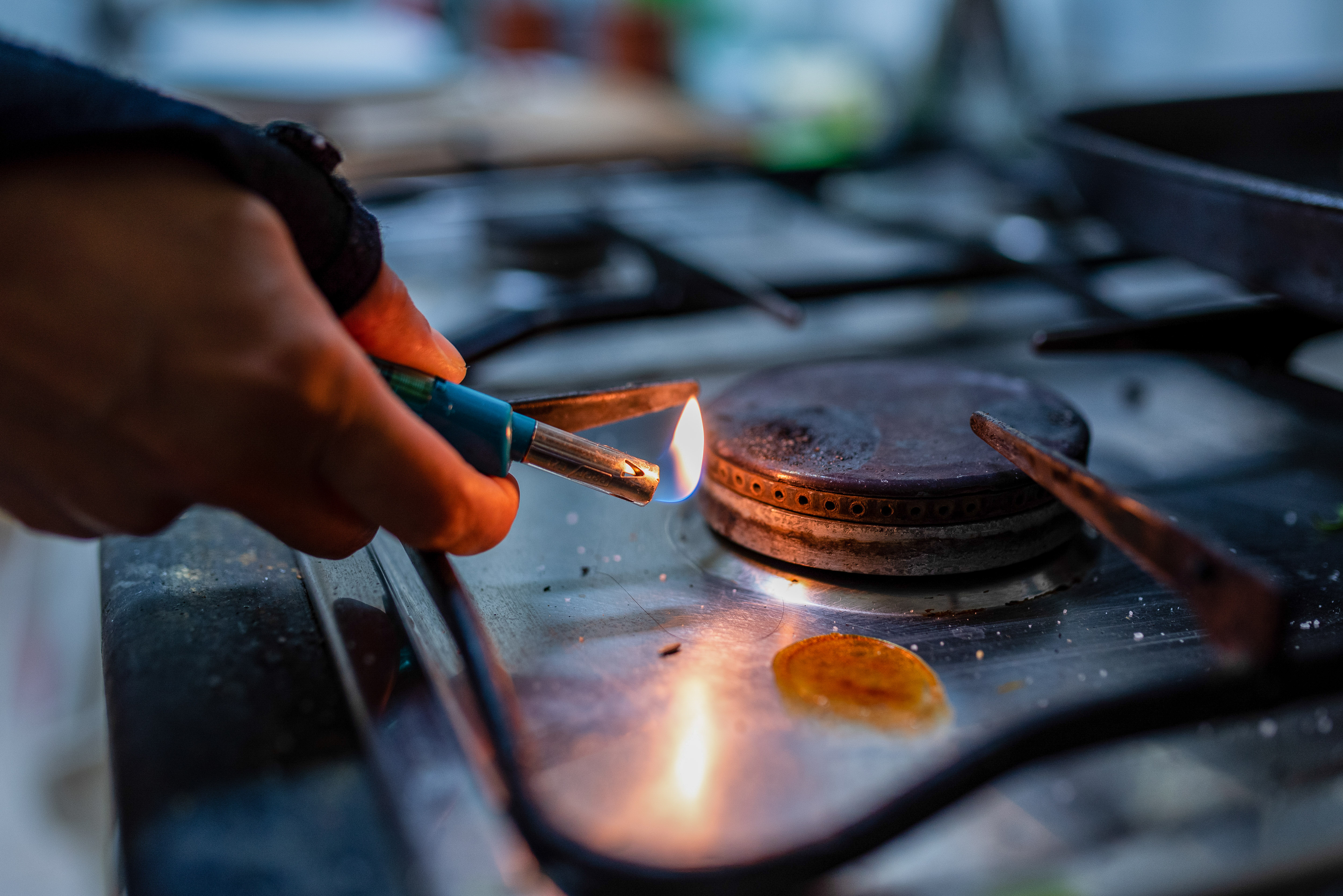 Une personne allume une cuisinière à gaz avec un briquet dans une maison | Source : Getty Images