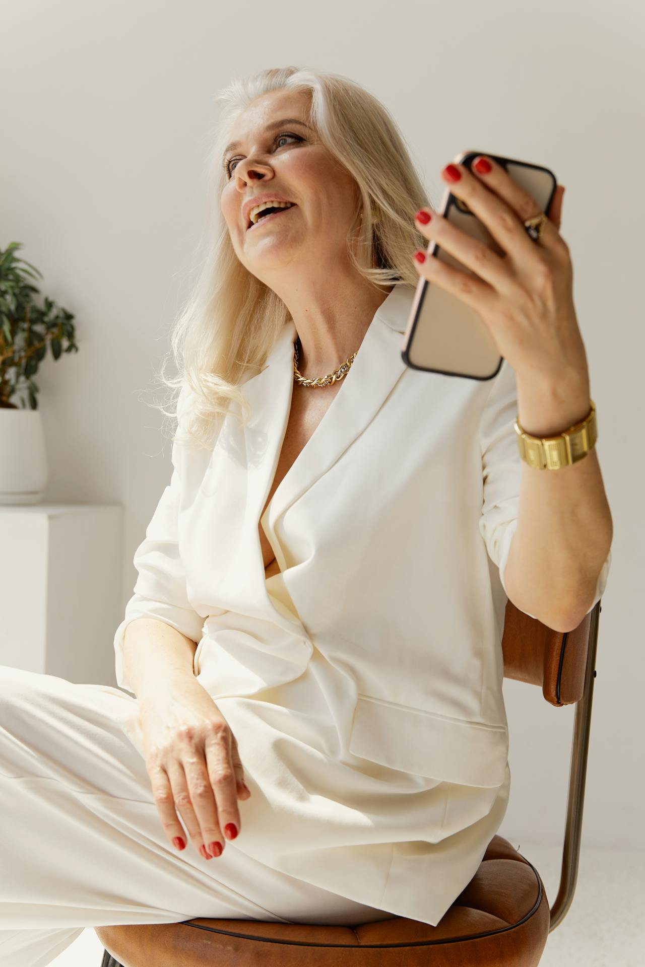 Une femme âgée souriante tenant son téléphone | Source : Pexels