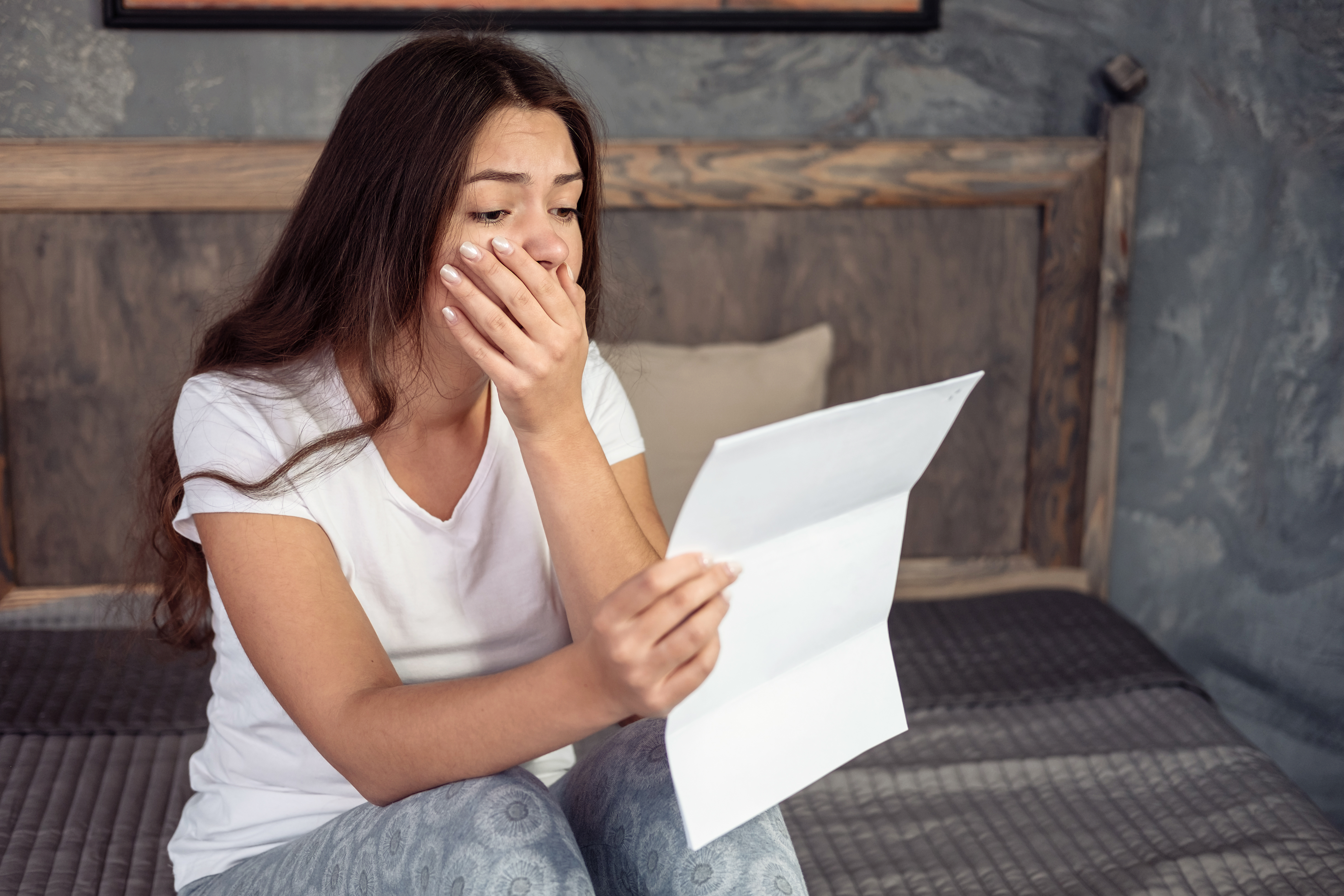 Une jeune femme choquée lisant une lettre | Source : Shutterstock