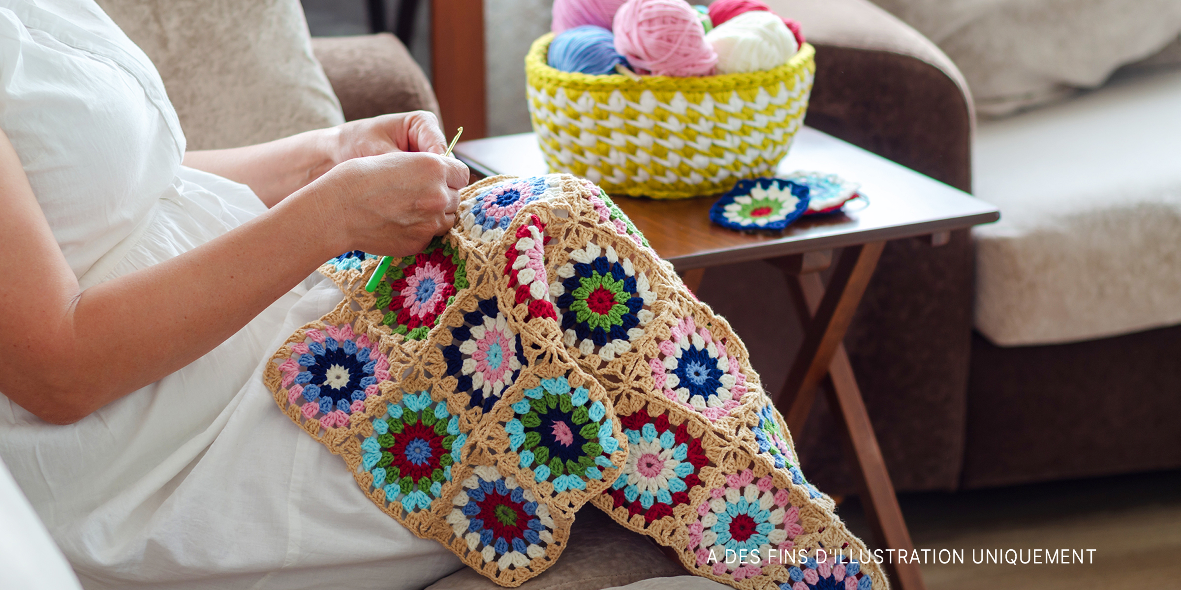 Femme crochetant une couverture pour bébé | Source : Shutterstock