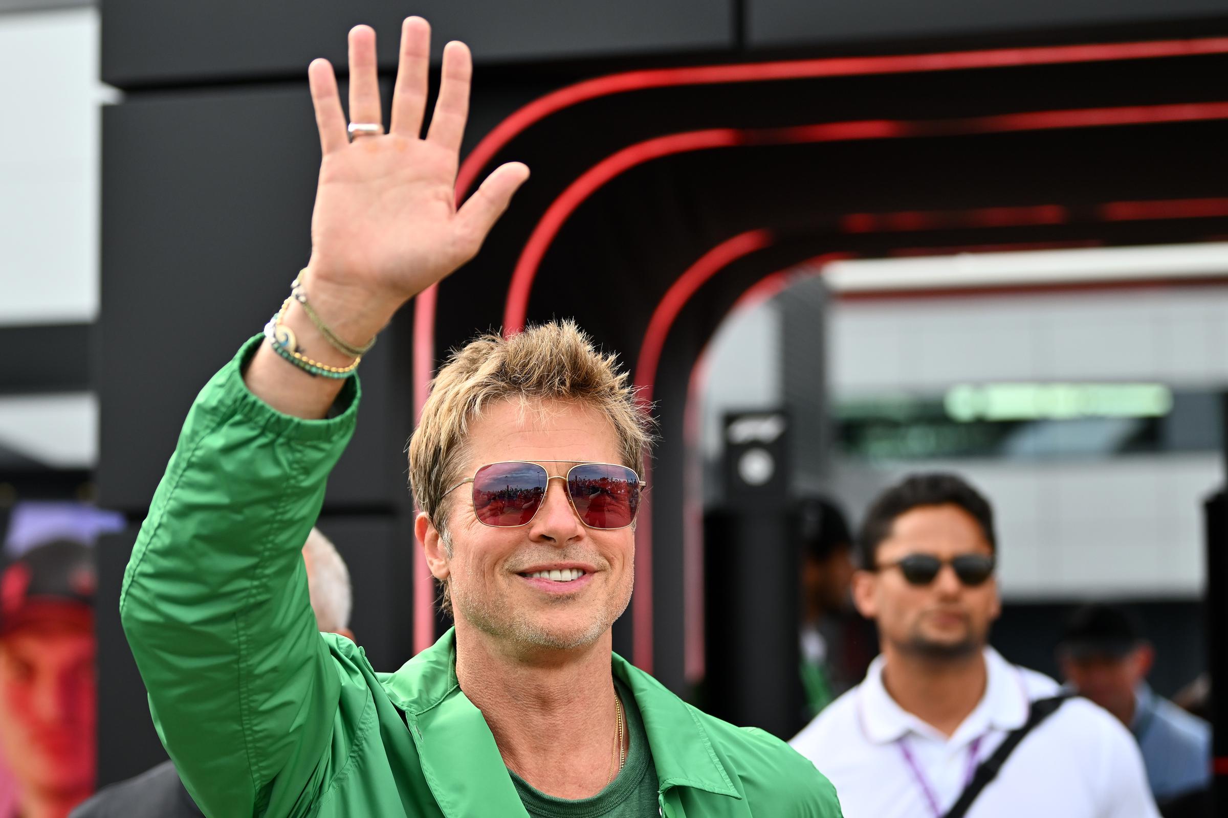 Brad Pitt salue en marchant dans le paddock après les qualifications du Grand Prix de Grande-Bretagne de F1 au circuit de Silverstone à Northampton, en Angleterre, le 8 juillet 2023. | Source : Getty Images