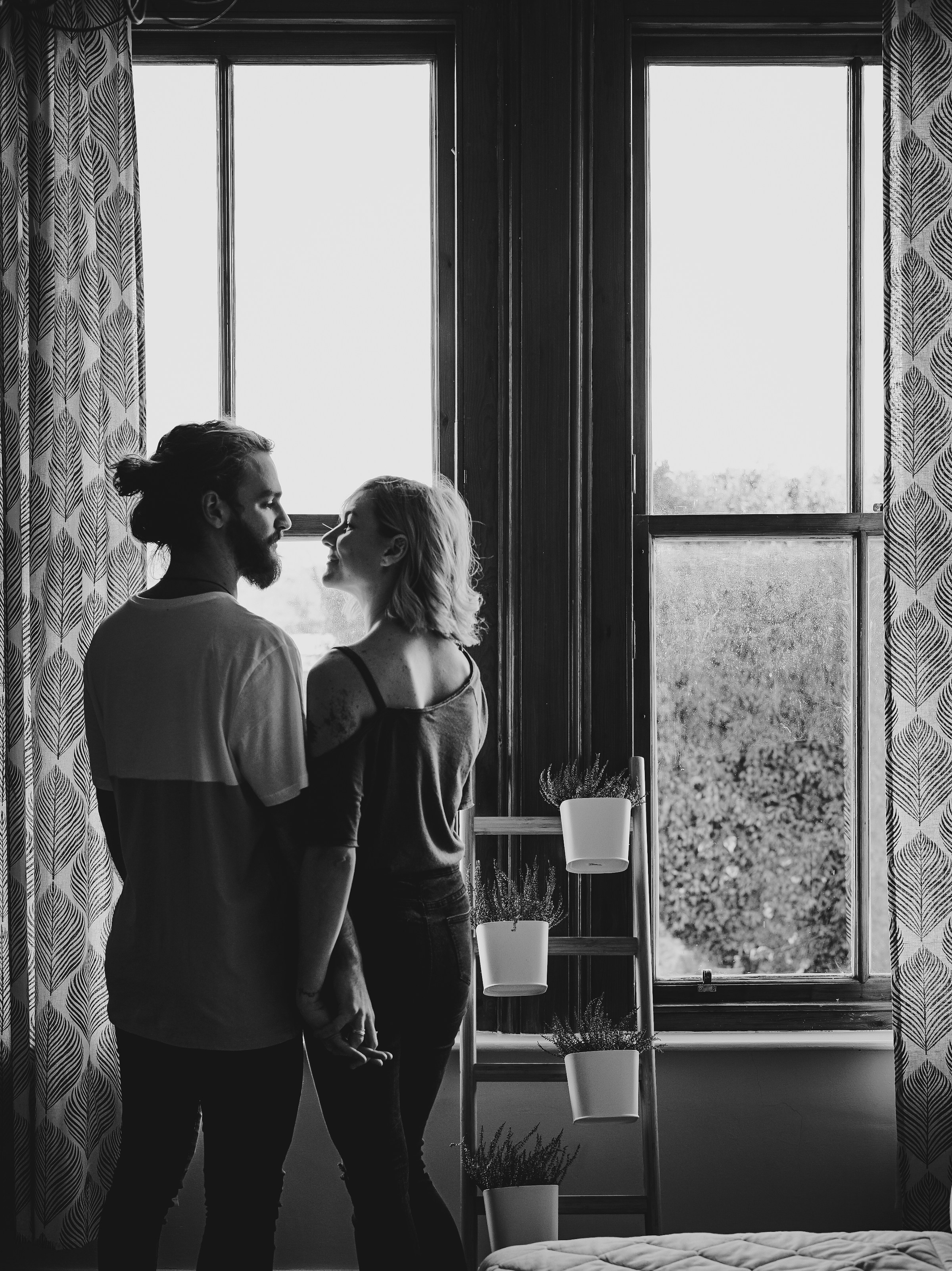 Un couple souriant près d'une fenêtre | Source : Unsplash