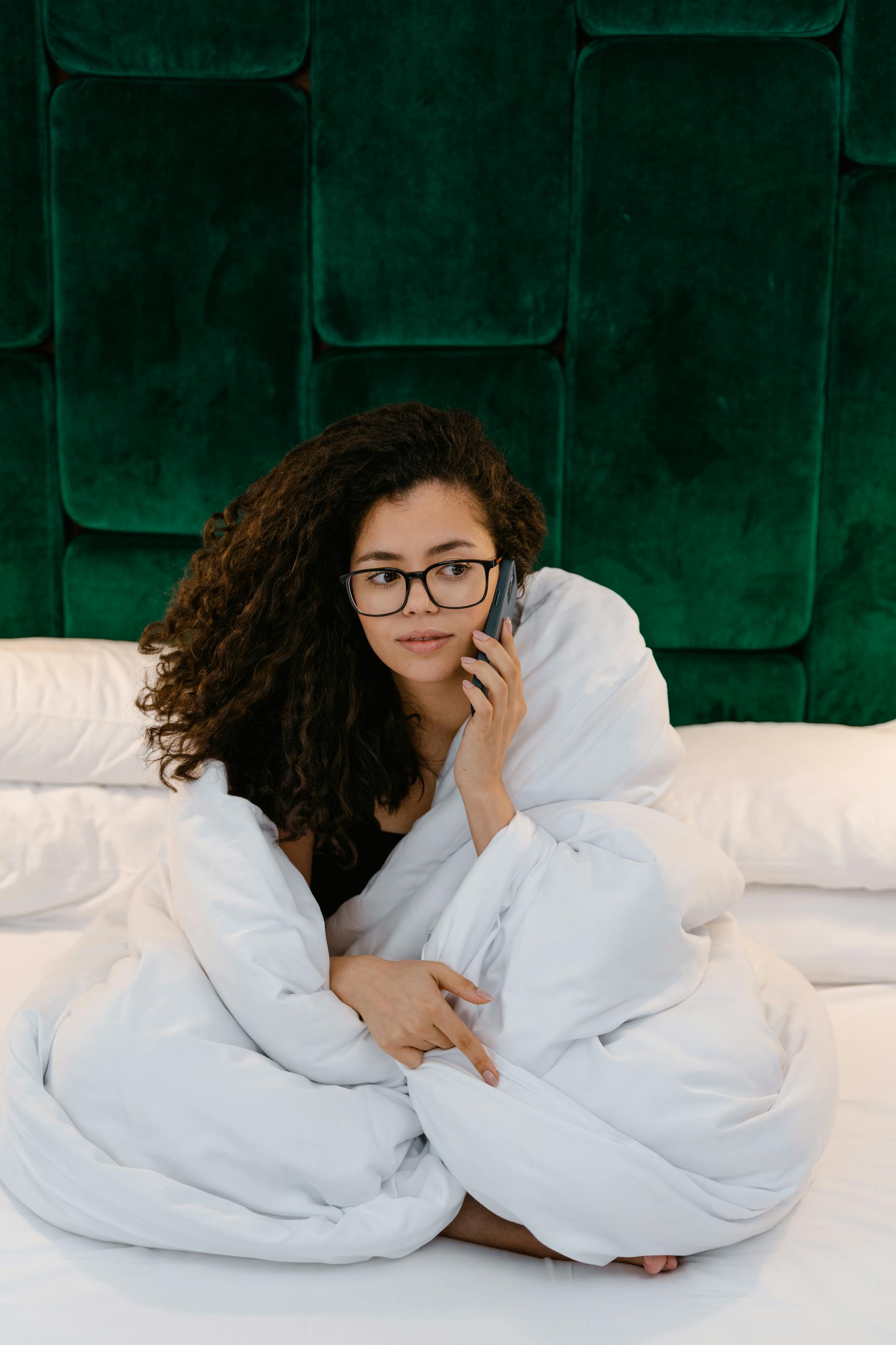 Une femme au lit répondant à un appel téléphonique | Source : Pexels
