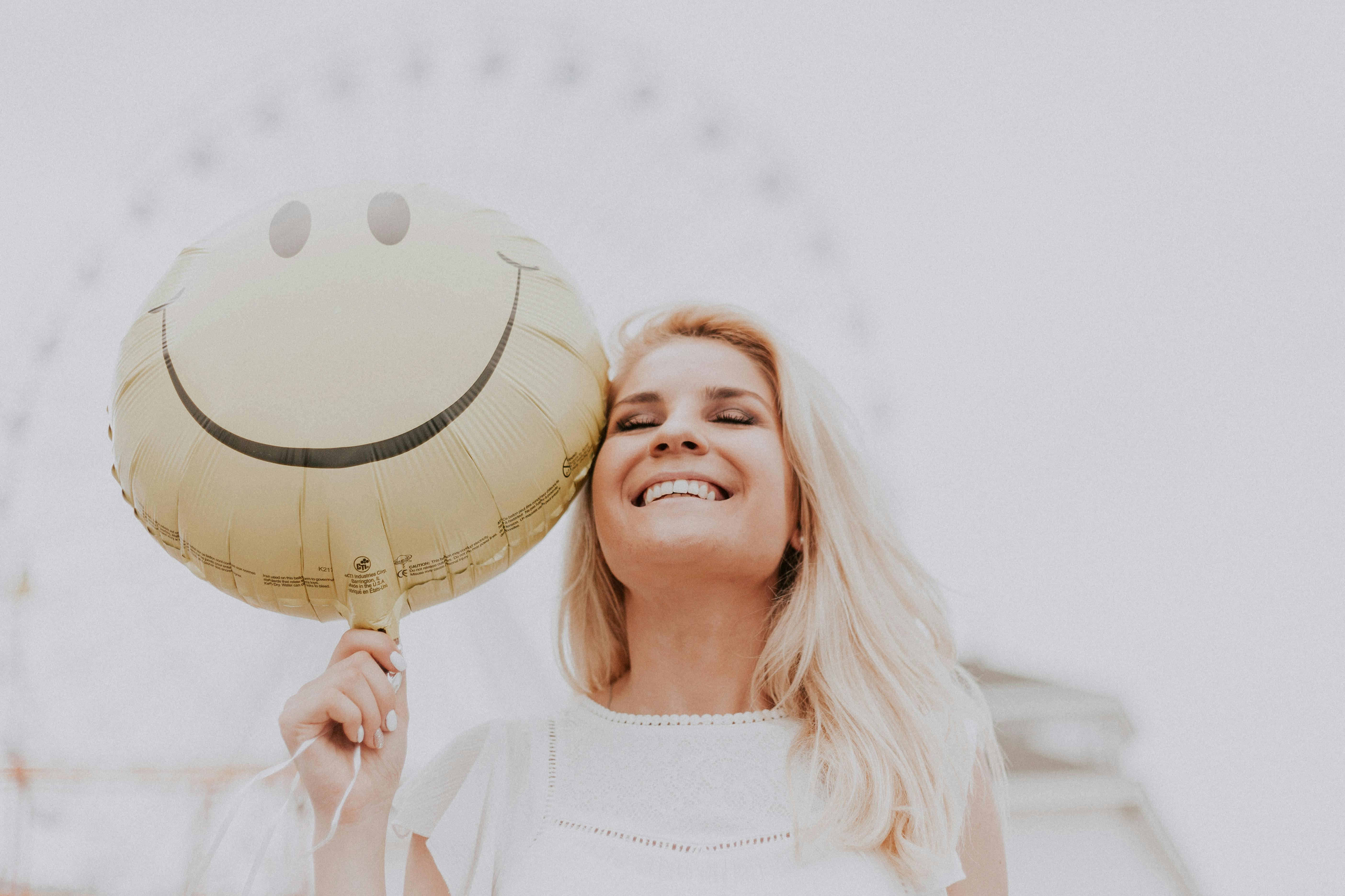 Femme tenant un ballon smiley | Source : Pexels