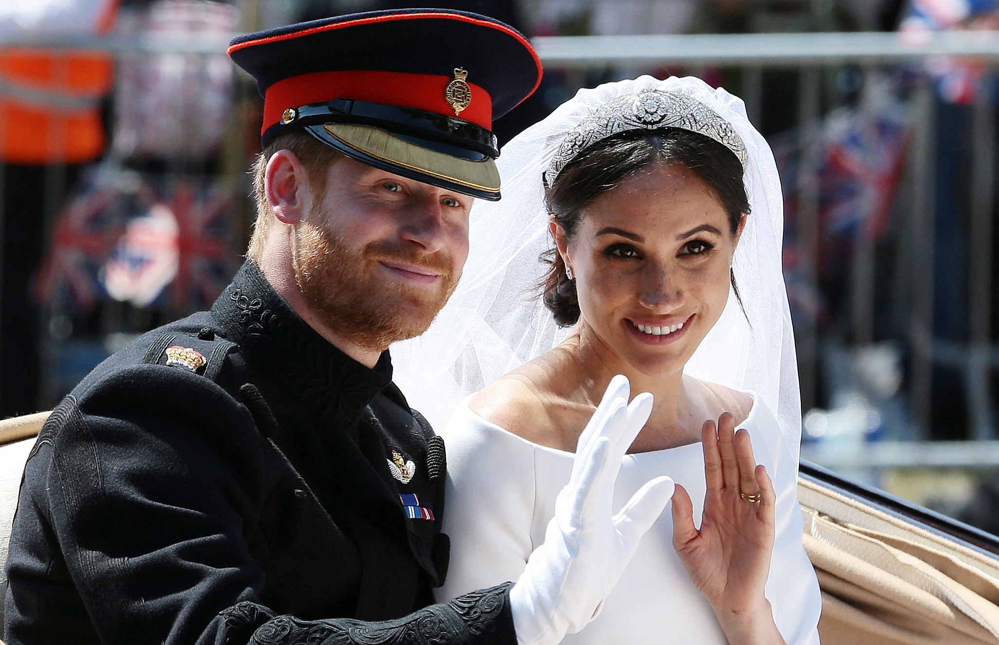 Le prince Harry et Meghan Markle saluent depuis la calèche Ascot Landau pendant leur procession en calèche le jour de leur mariage, le 19 mai 2018 à Windsor, en Angleterre. | Source : Getty Images