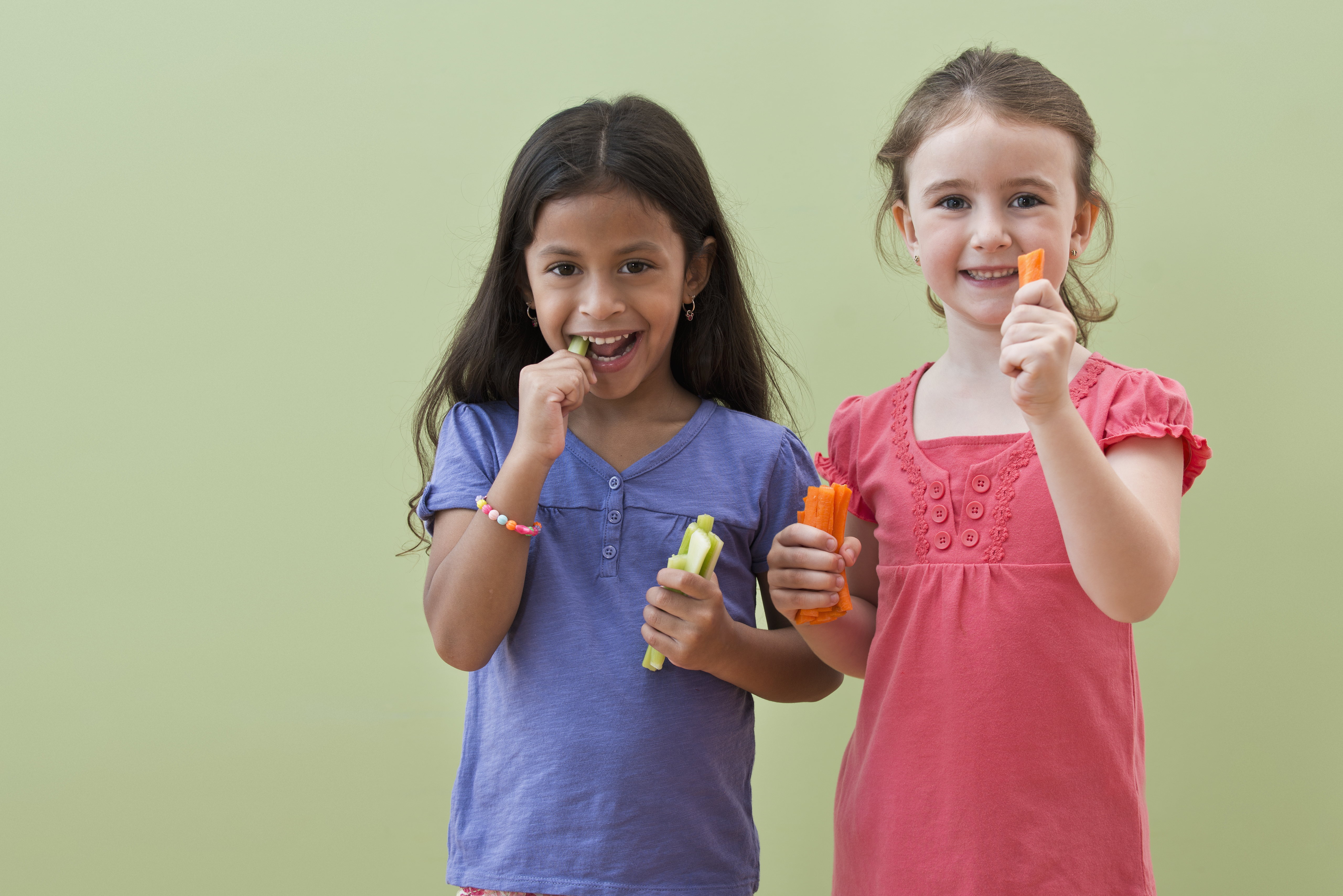 Des filles qui mangent ensemble des bâtonnets de légumes | Source : Getty Images