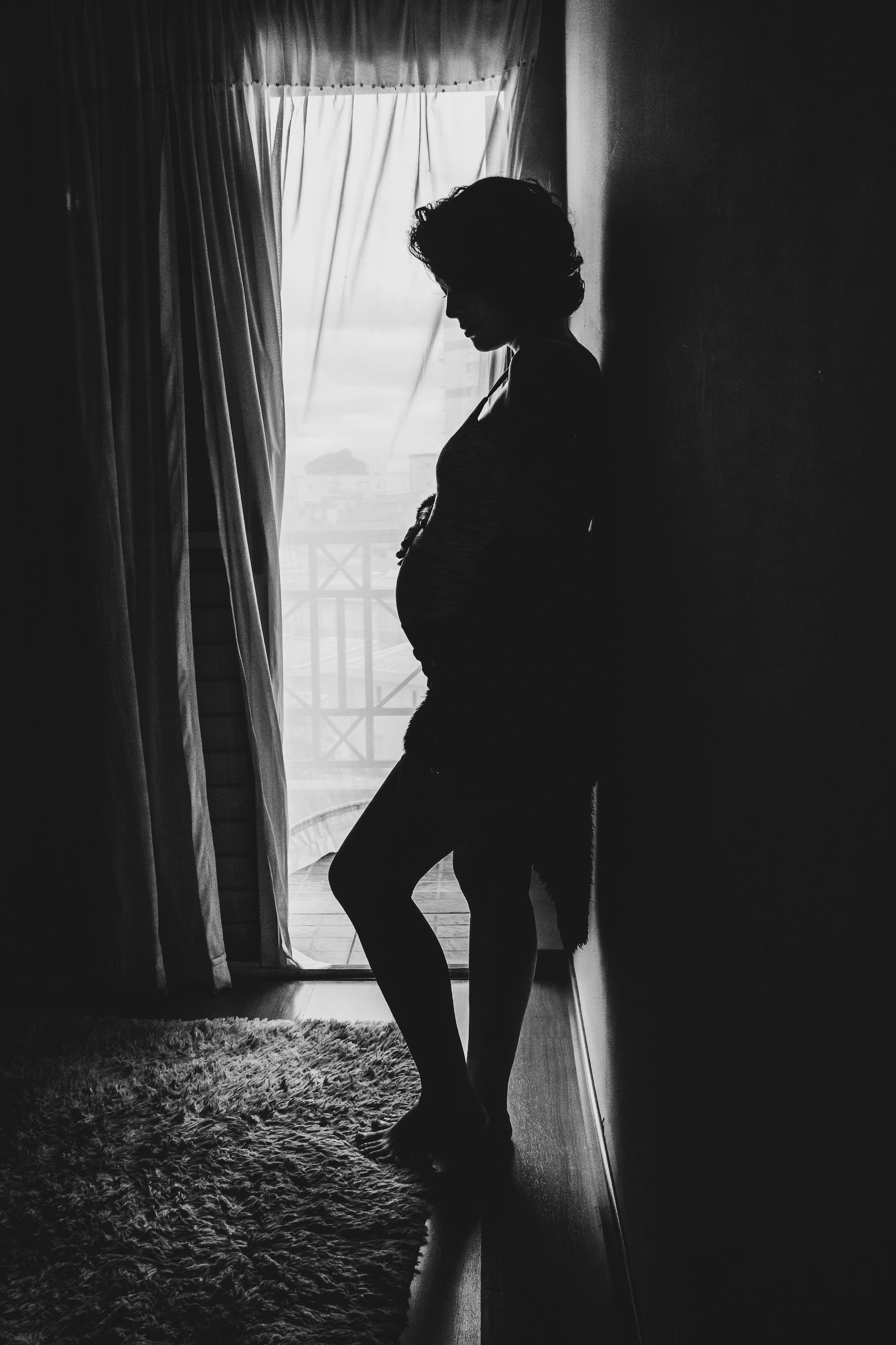 Silhouette d'une femme enceinte debout contre un mur | Source : Pexels