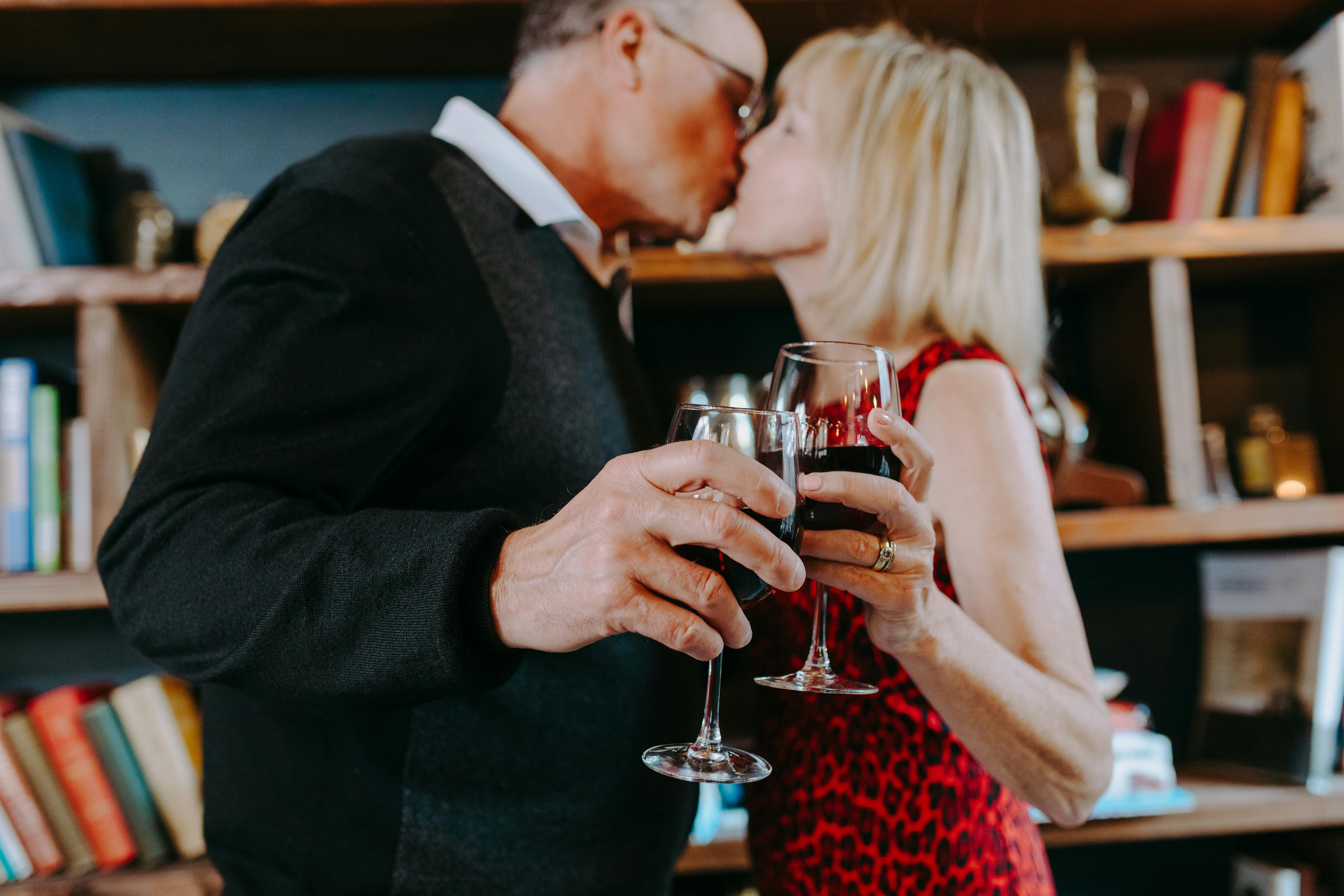 Un couple partageant un toast et un baiser | Source : Pexels