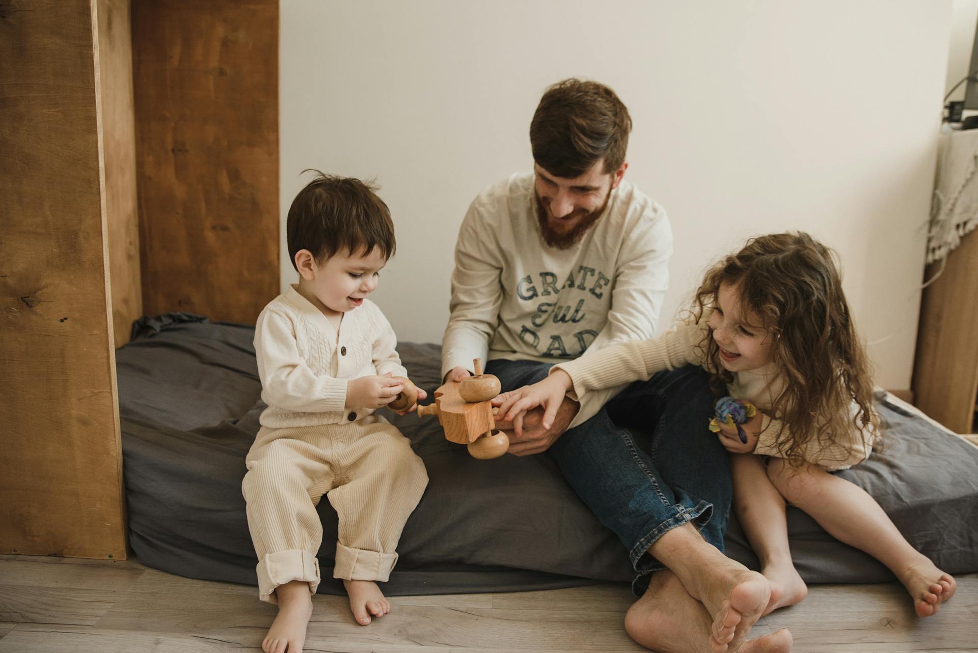 Un homme jouant avec deux enfants | Source : Pexels