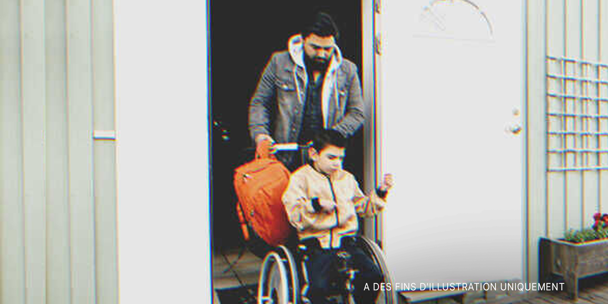 Un homme poussant un garçon en fauteuil roulant | Source : Getty Images