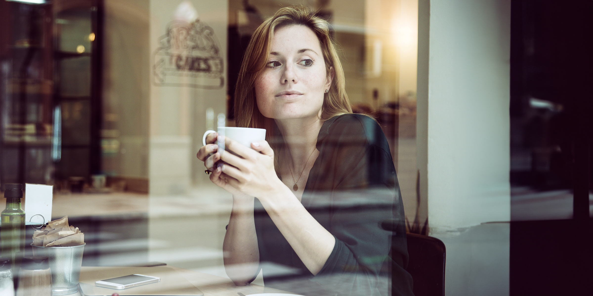 Une femme assise dans un café | Source : freepik.com/freepik