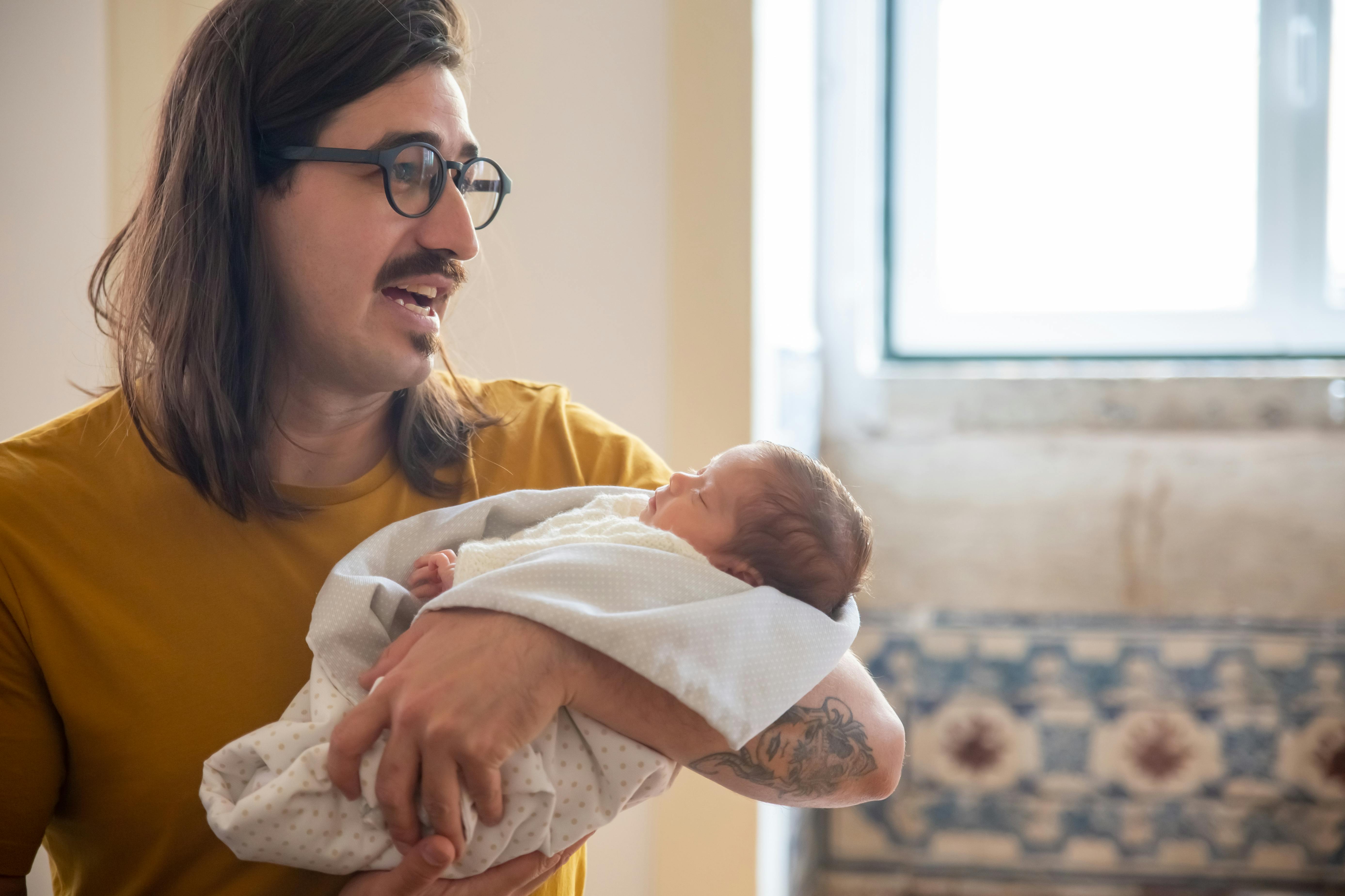 Un homme berçant un bébé | Source : Pexels